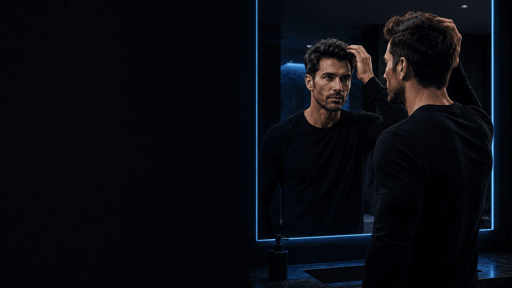 Man checking his hair in a mirror for hair restoration