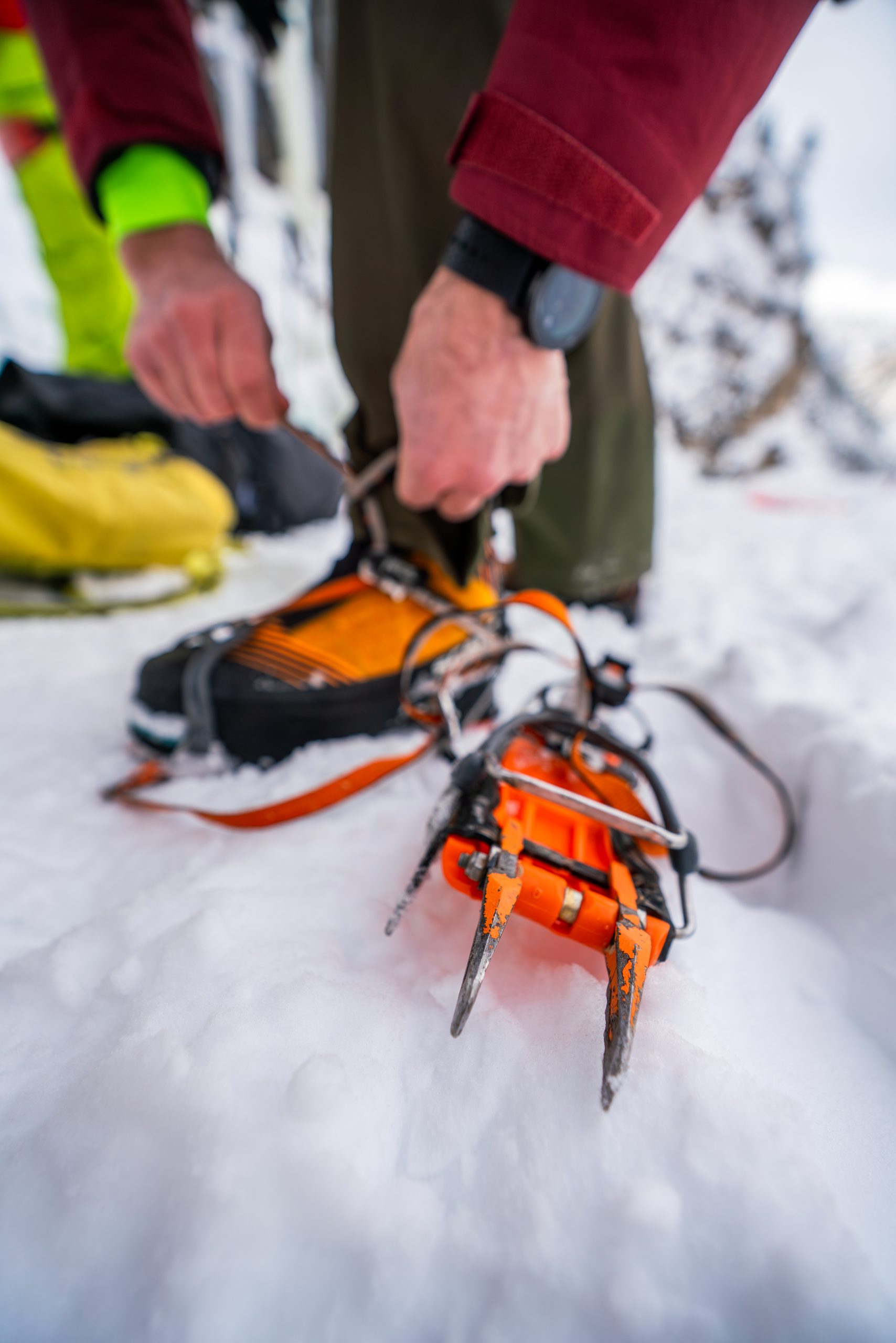 Ice climbing equipment including crampons and boots used during a beginner ice climbing fundamentals clinic course in the Adamello Dolomites.