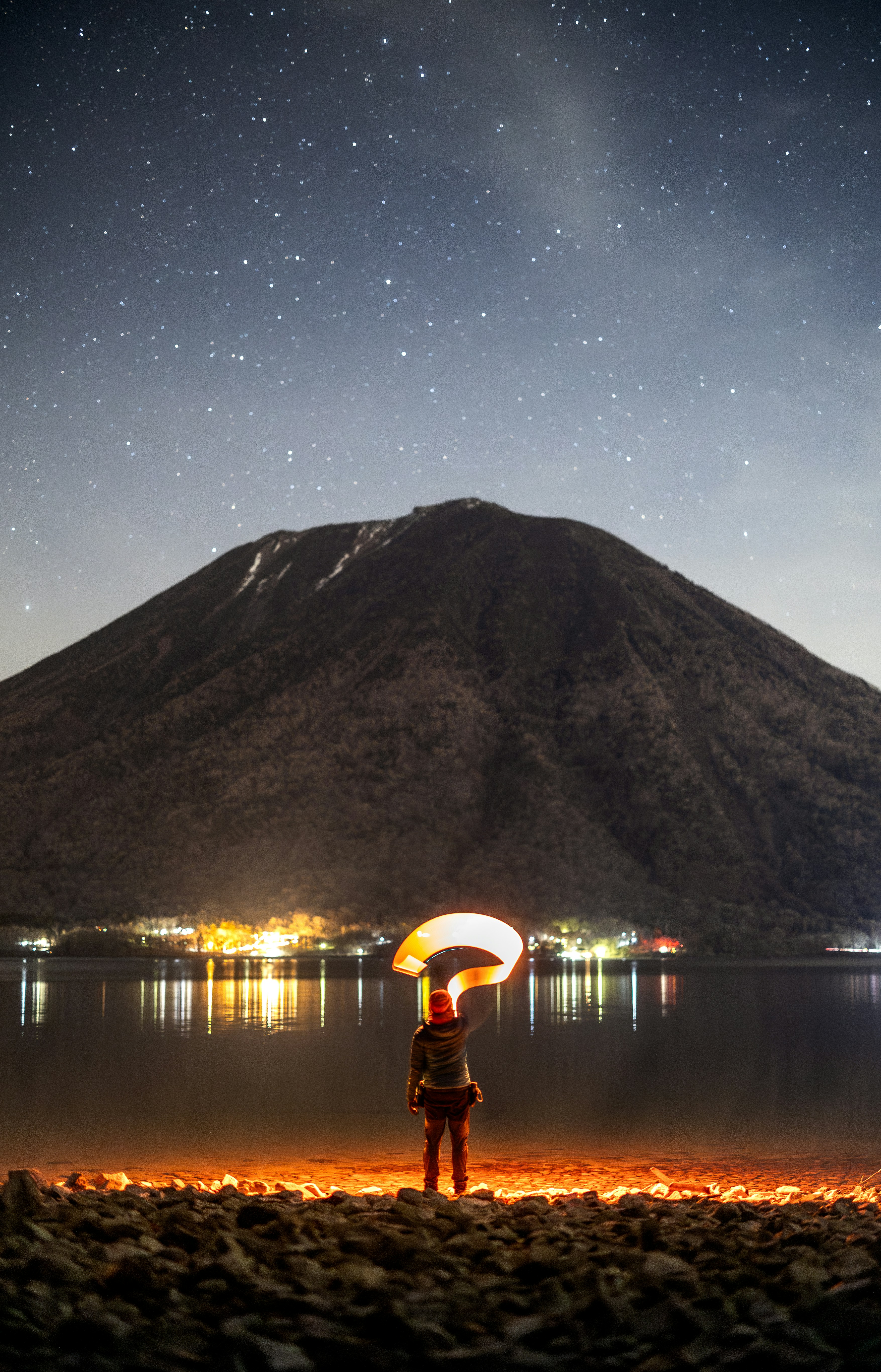 A person forms a question mark with light.