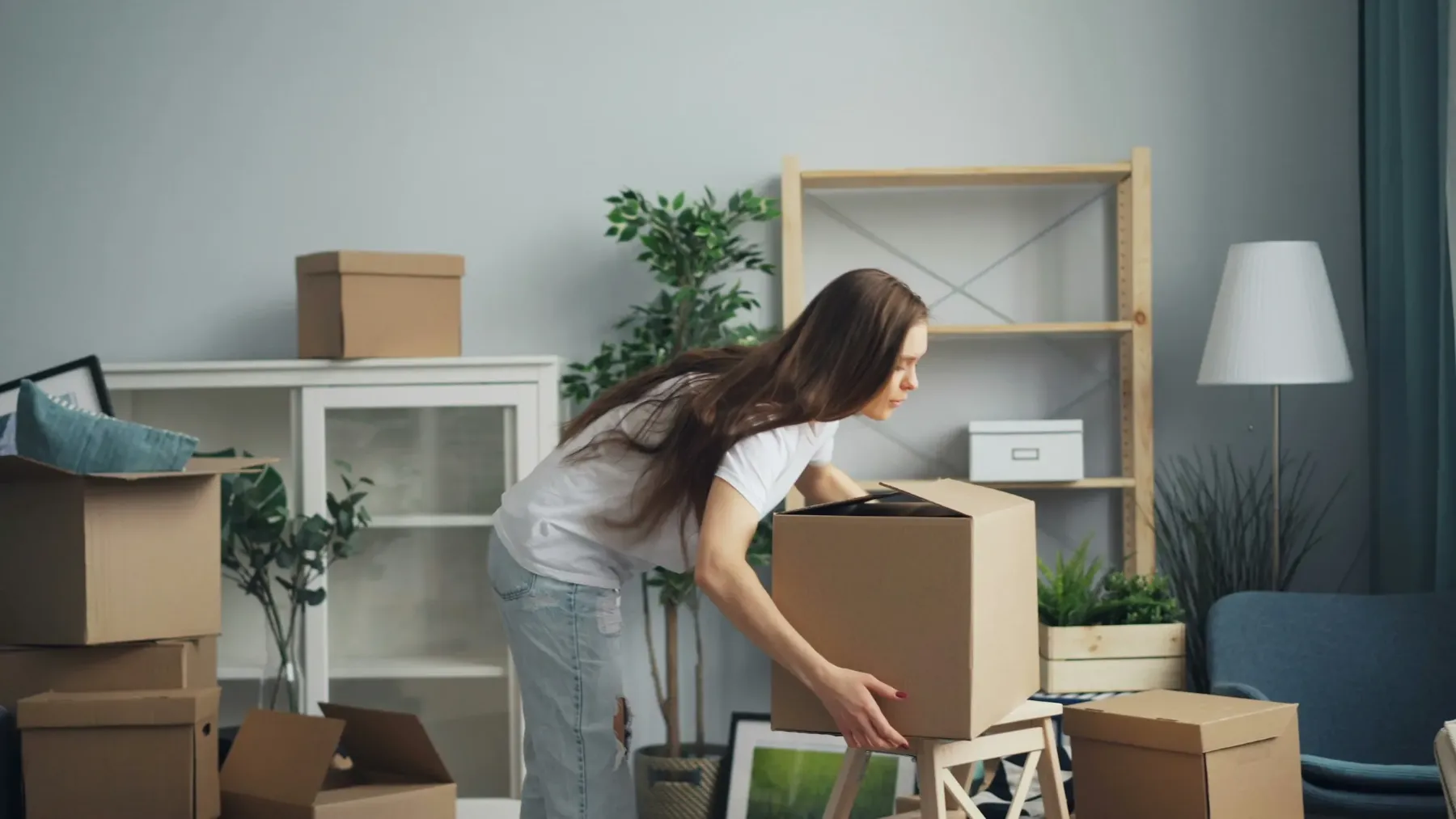 Joven empaquetando sus muebles durante una mudanza a un nuevo piso. Contrata el Seguro de Hogar para Inquilinos Allianz con la agencia AMB Seguros en Murcia y salva tu fianza.