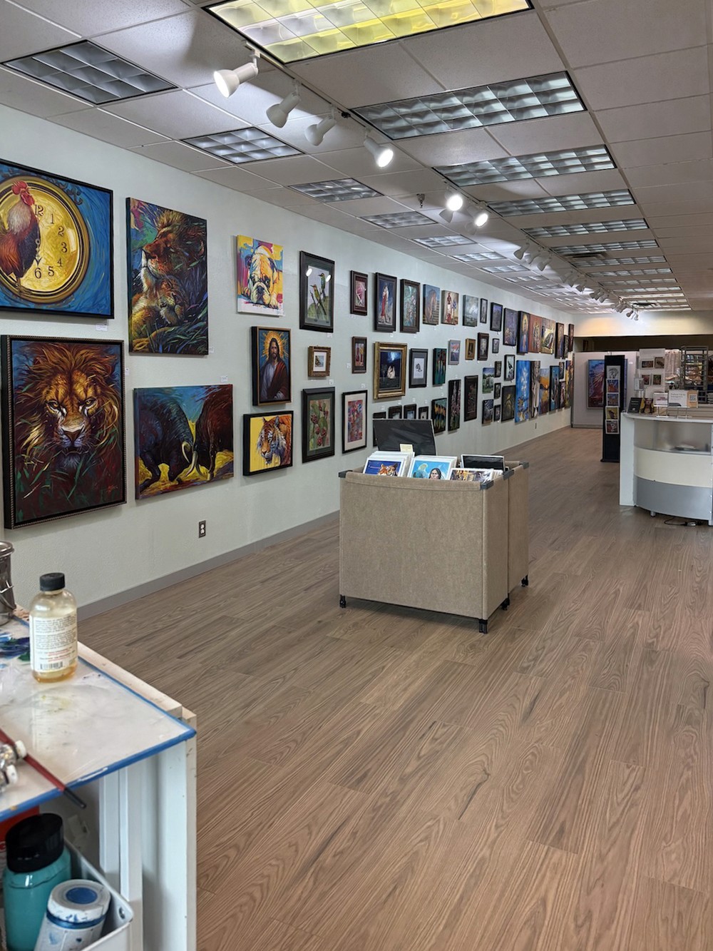 Interior of 520 Arts Gallery with rows of colorful animal and portrait paintings hung along both walls