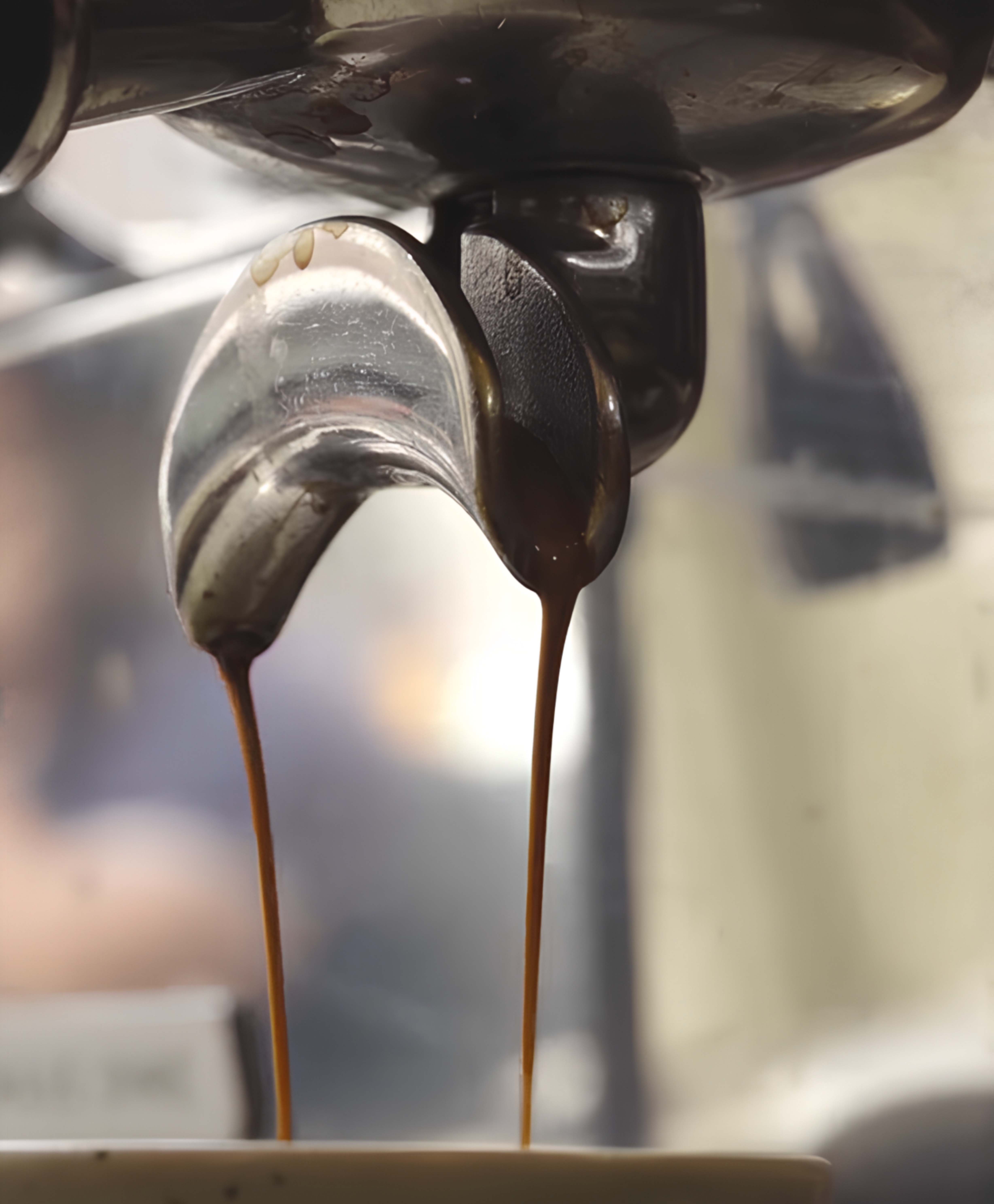 Close-up shot of melted chocolate pouring from a metal spout for Koub promotional assets.