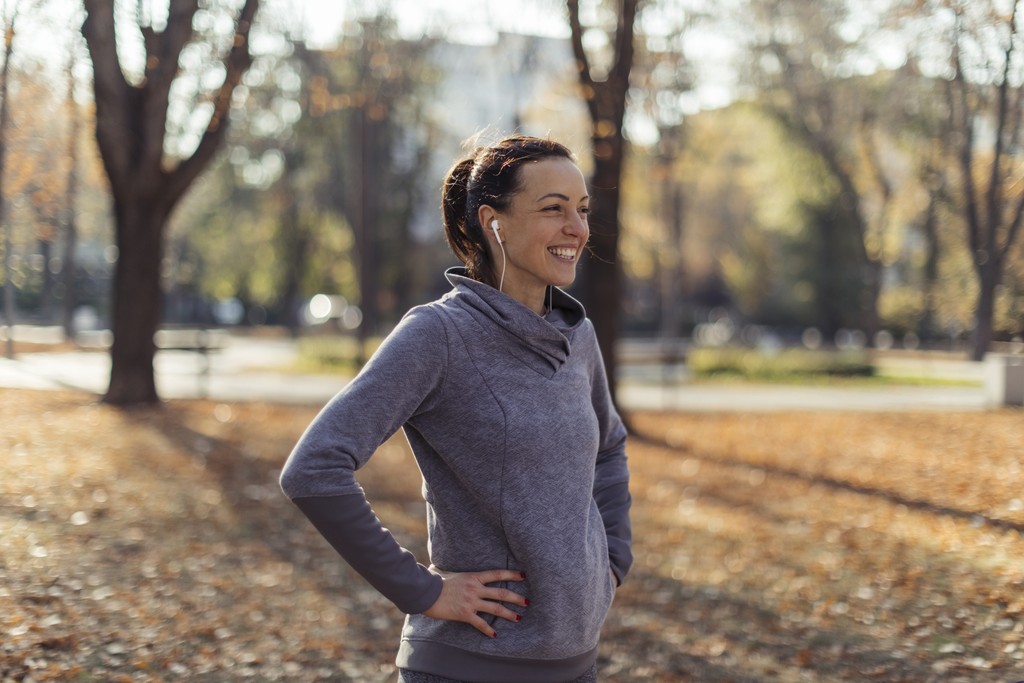 Picture of a woman exercising with headphones in with diabetes, happy after using the enhance-d app