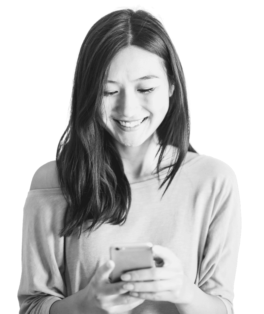 A woman with long hair, wearing a light sweater, smiles while looking at her smartphone, symbolizing connectivity and modern communication, aligning with strategic bond trading concepts.