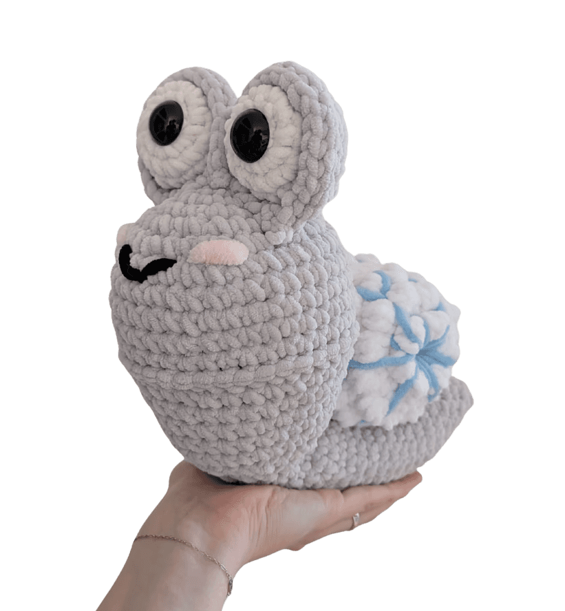 A cute, handcrafted plush acorn toy with brown yarn spikes and large, friendly eyes sits facing forward on a white background.