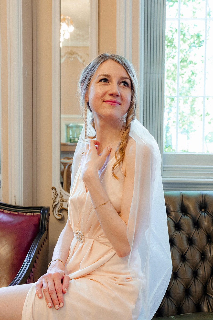Luxury bridal portrait in a historic interior with soft daylight and delicate styling