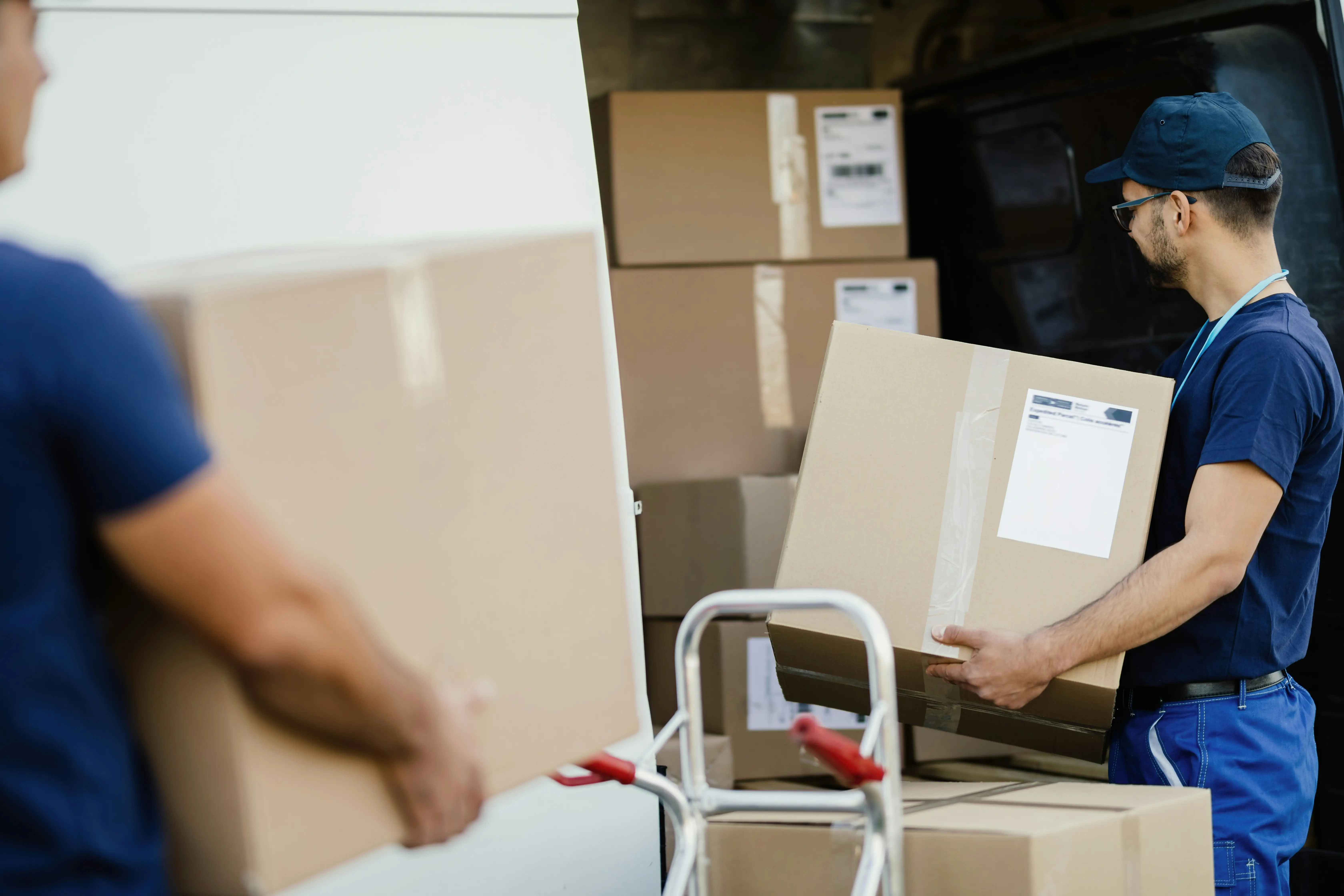 delivery men unloading a packed van full of parcels