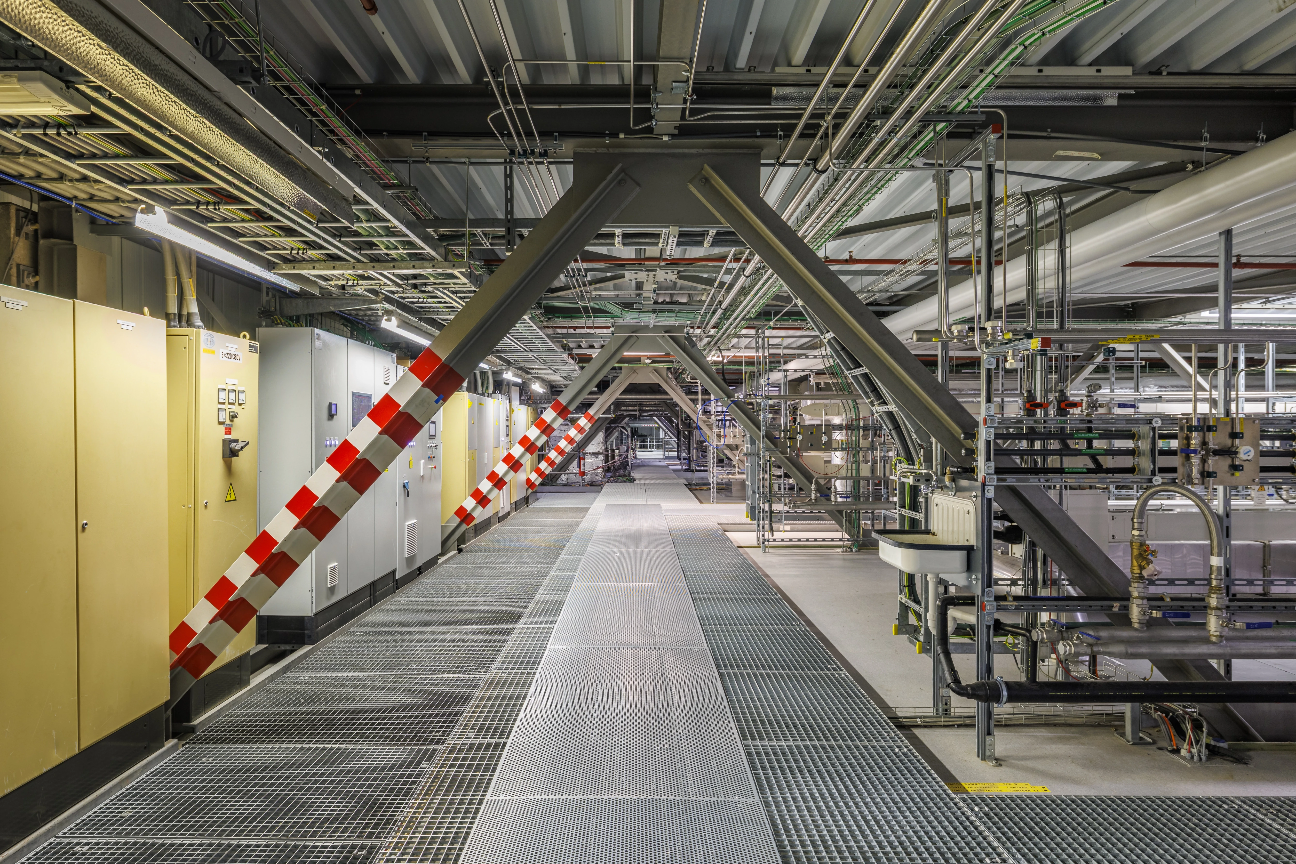 Hallway with beams set up diagonally and pipes on the right