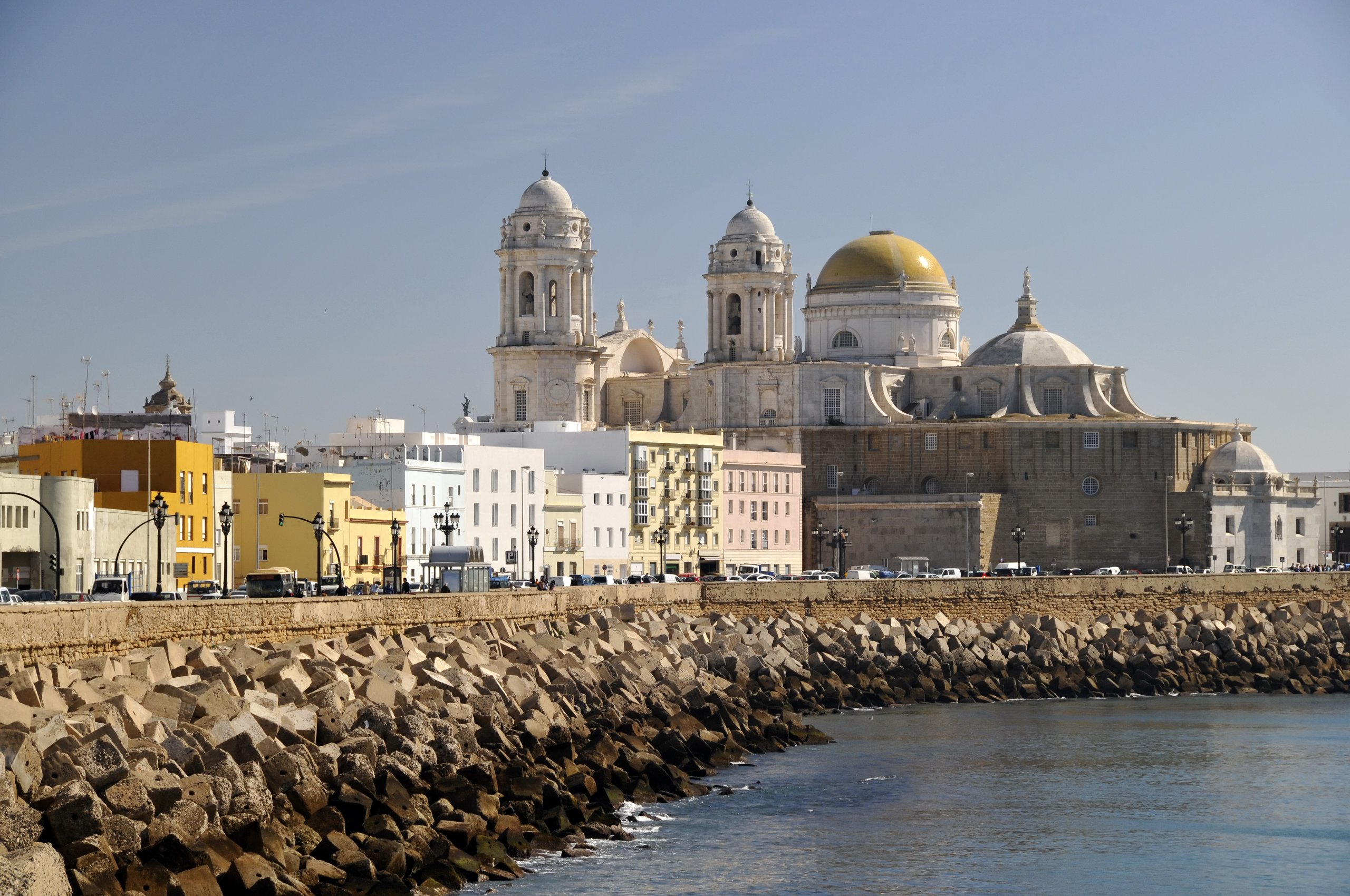 Cádiz Cathedral and its golden dome above the seafront breakwater, on Spain's Atlantic coast.