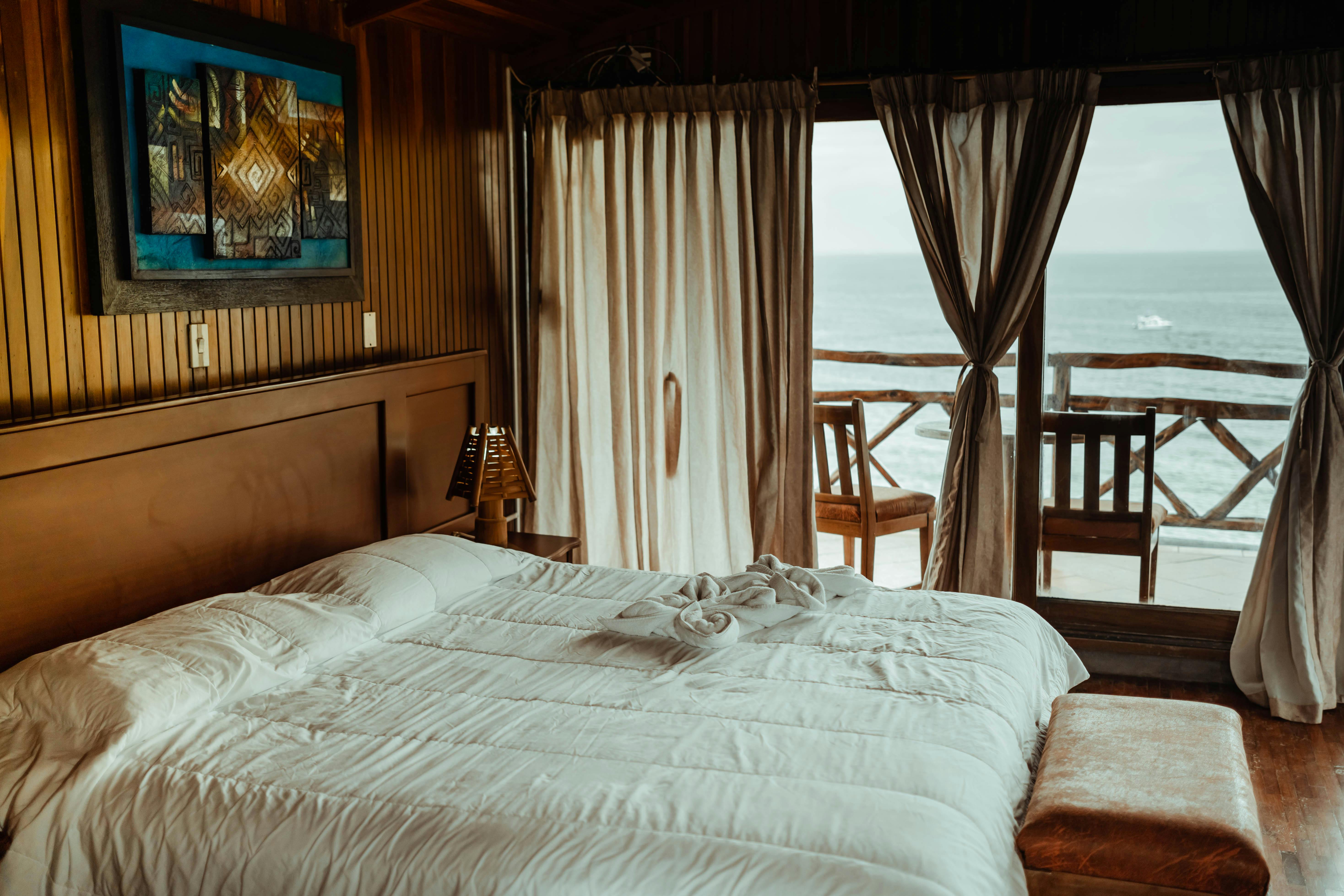 Habitación de hotel con cama doble y balcón al mar en Uruguay, alojamiento con vista al océano elegido con una aplicación de turismo con IA