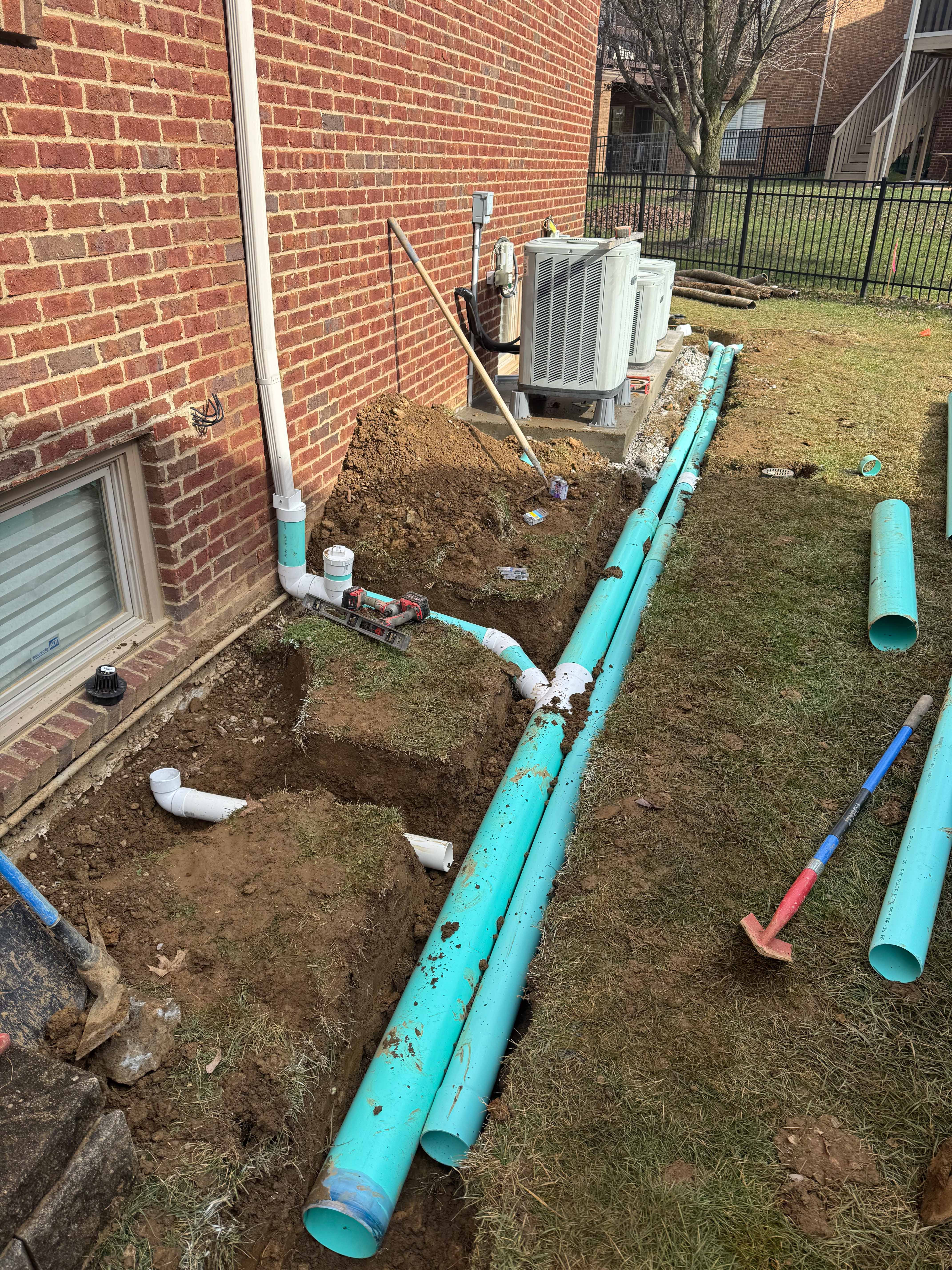 Trench work with drainage pipes leading from downspout to yard