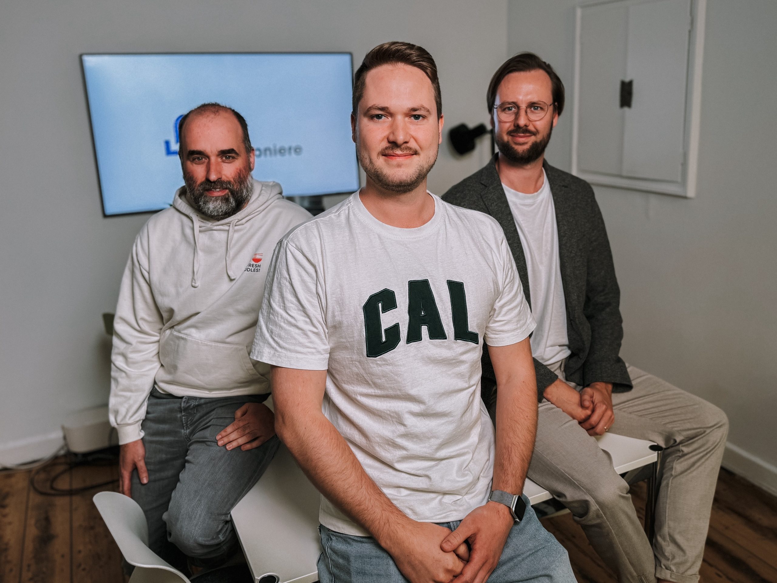 Stacked square glass jars filled with golden serum and bubbles, silver lids—luxury skincare packaging on a light background.