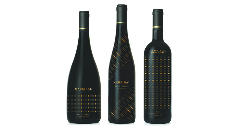 three black alcohol bottles with golden dots and text on the label