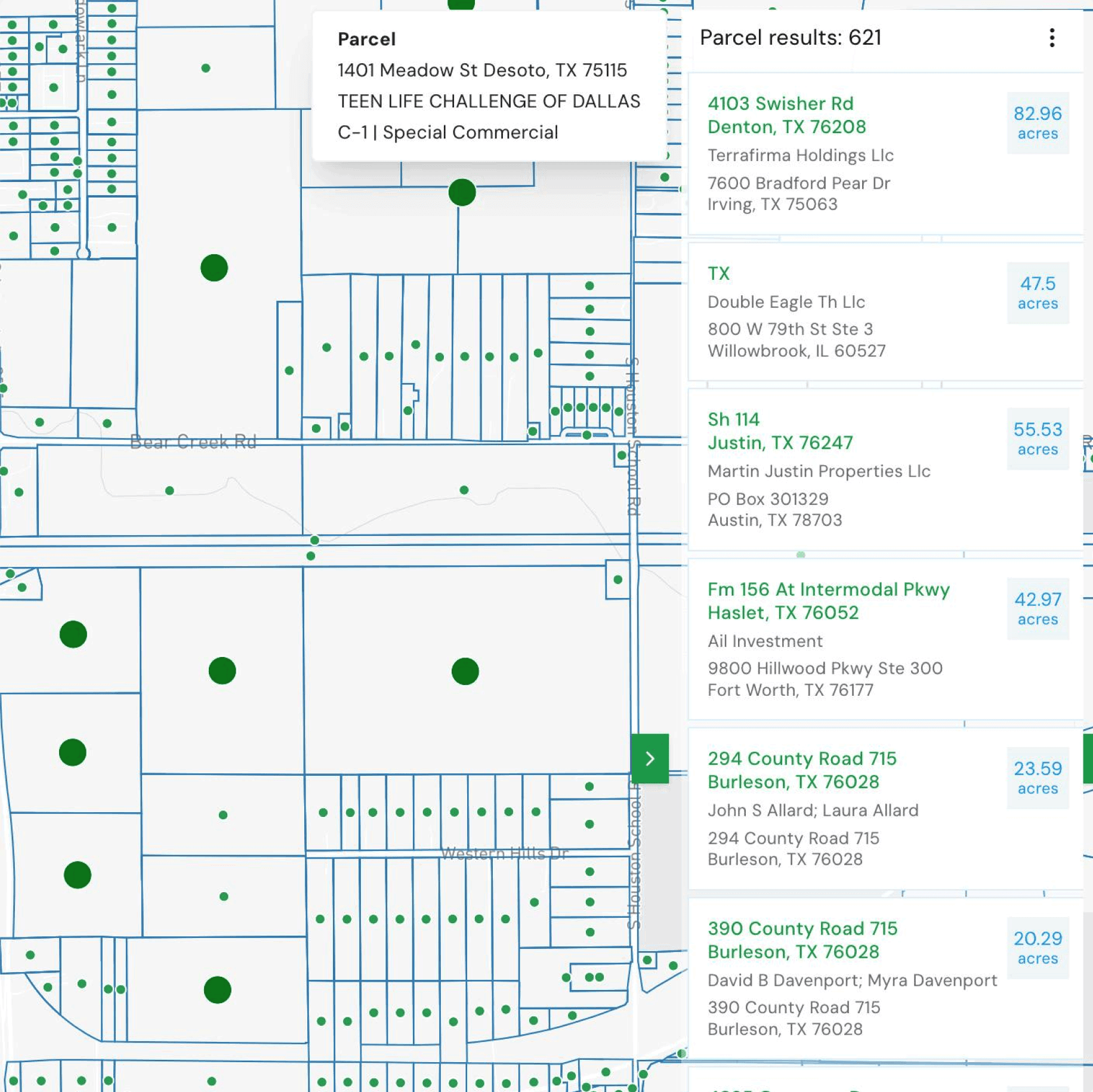 A winding road cuts through rocky terrain, surrounded by patches of green grass and illuminated by sunlight.