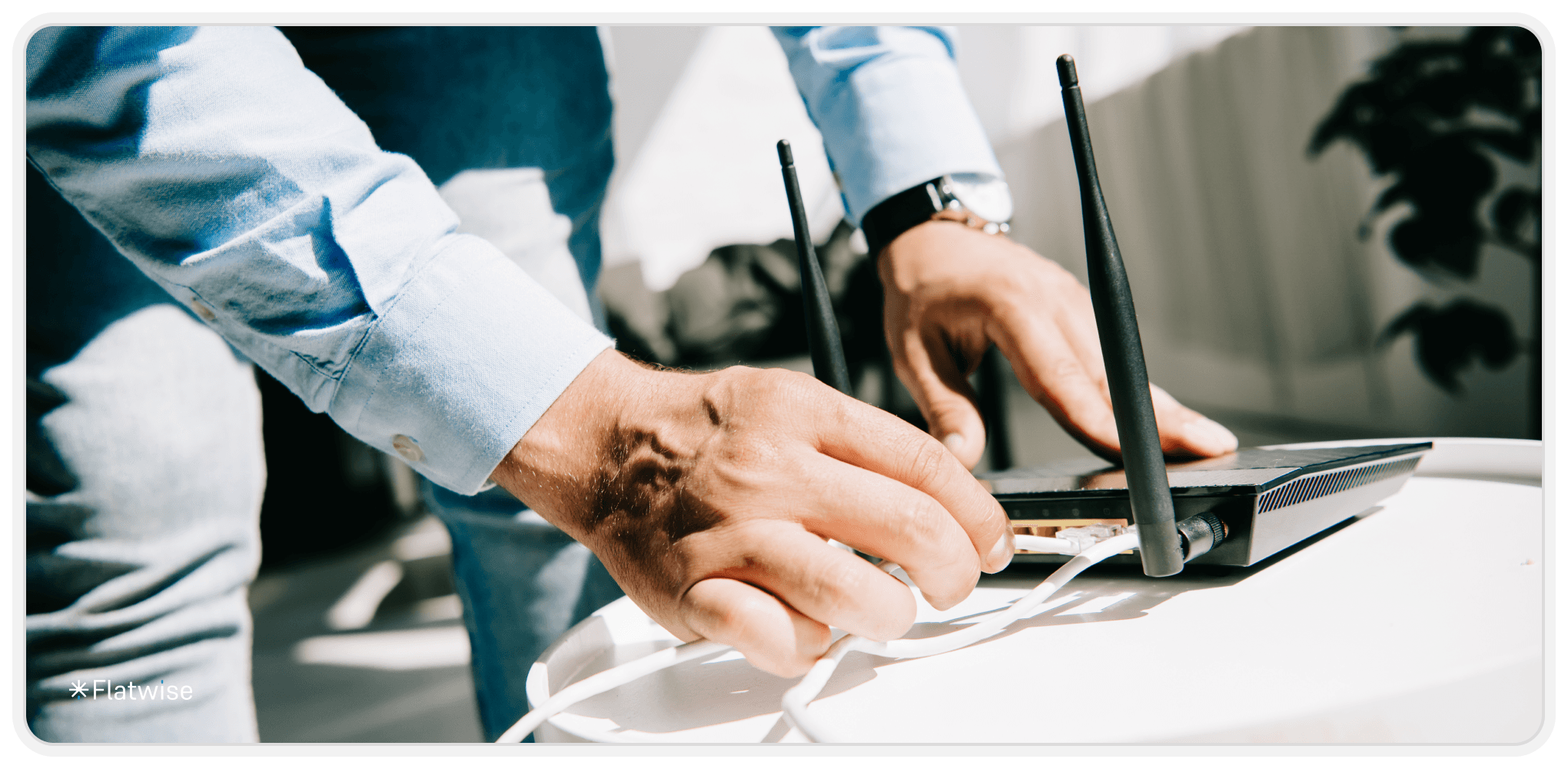 Mann mit Hemd verbinet LAN-Kabel mit WLAN-Router.