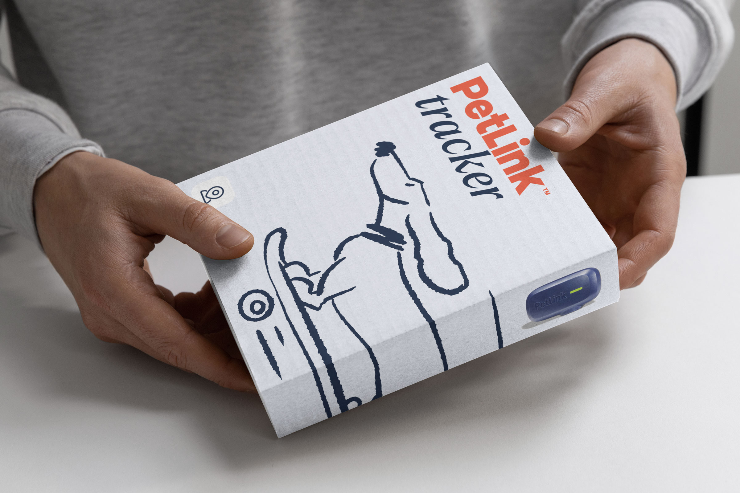 Hands holding packaging of the PetLink GPS tracker