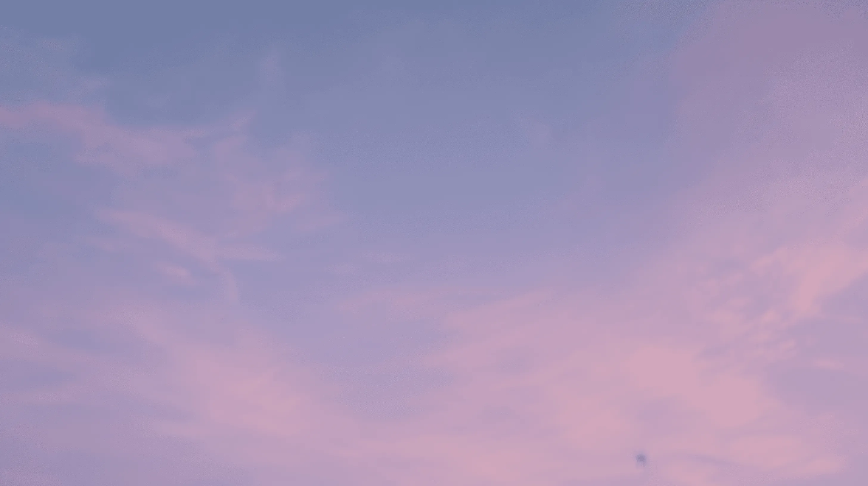 Lucht met blauwpaarse tinten en zachte wolken.