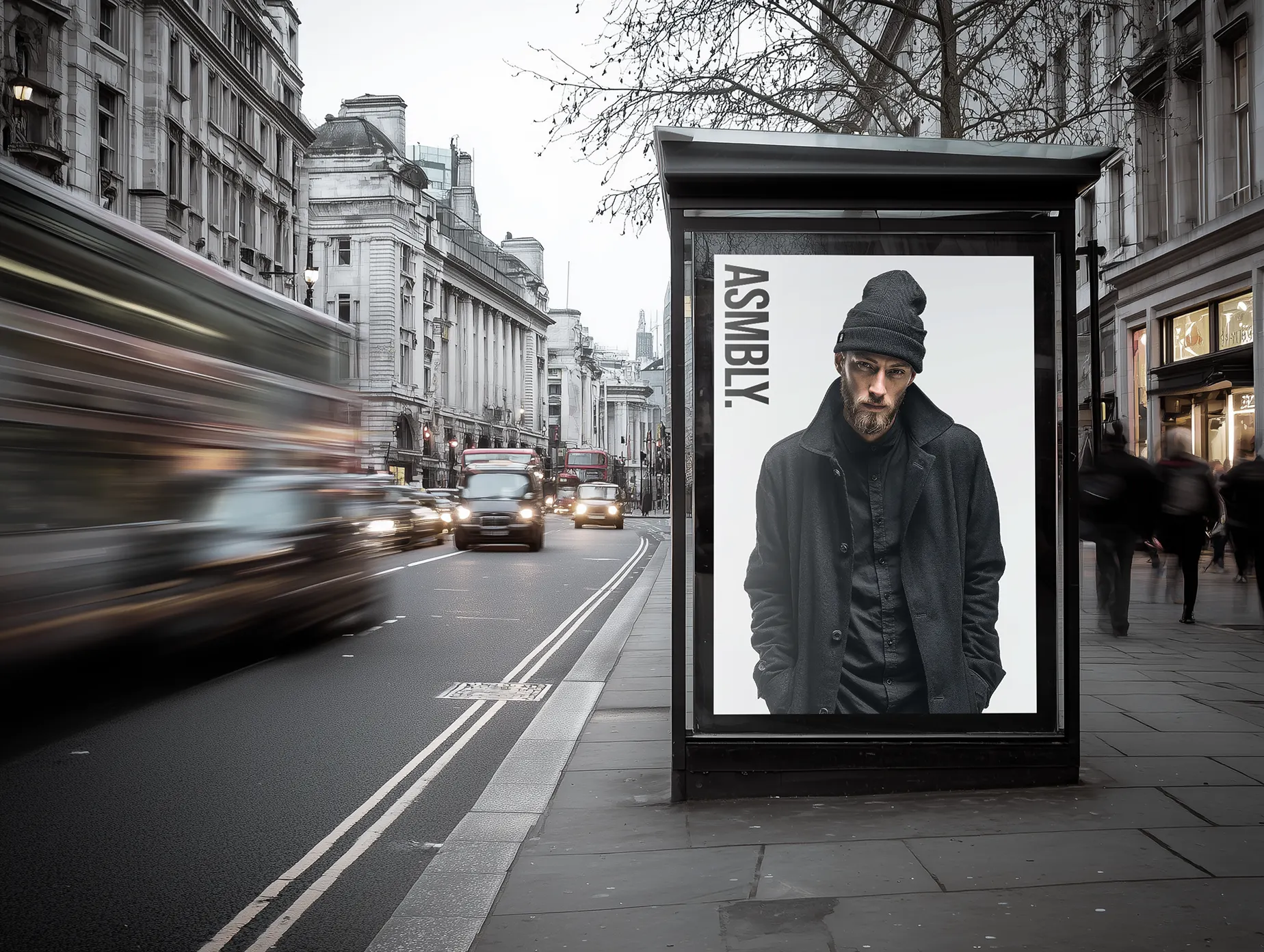 Street advertising display featuring an Assembly fashion campaign poster in an urban city setting.
