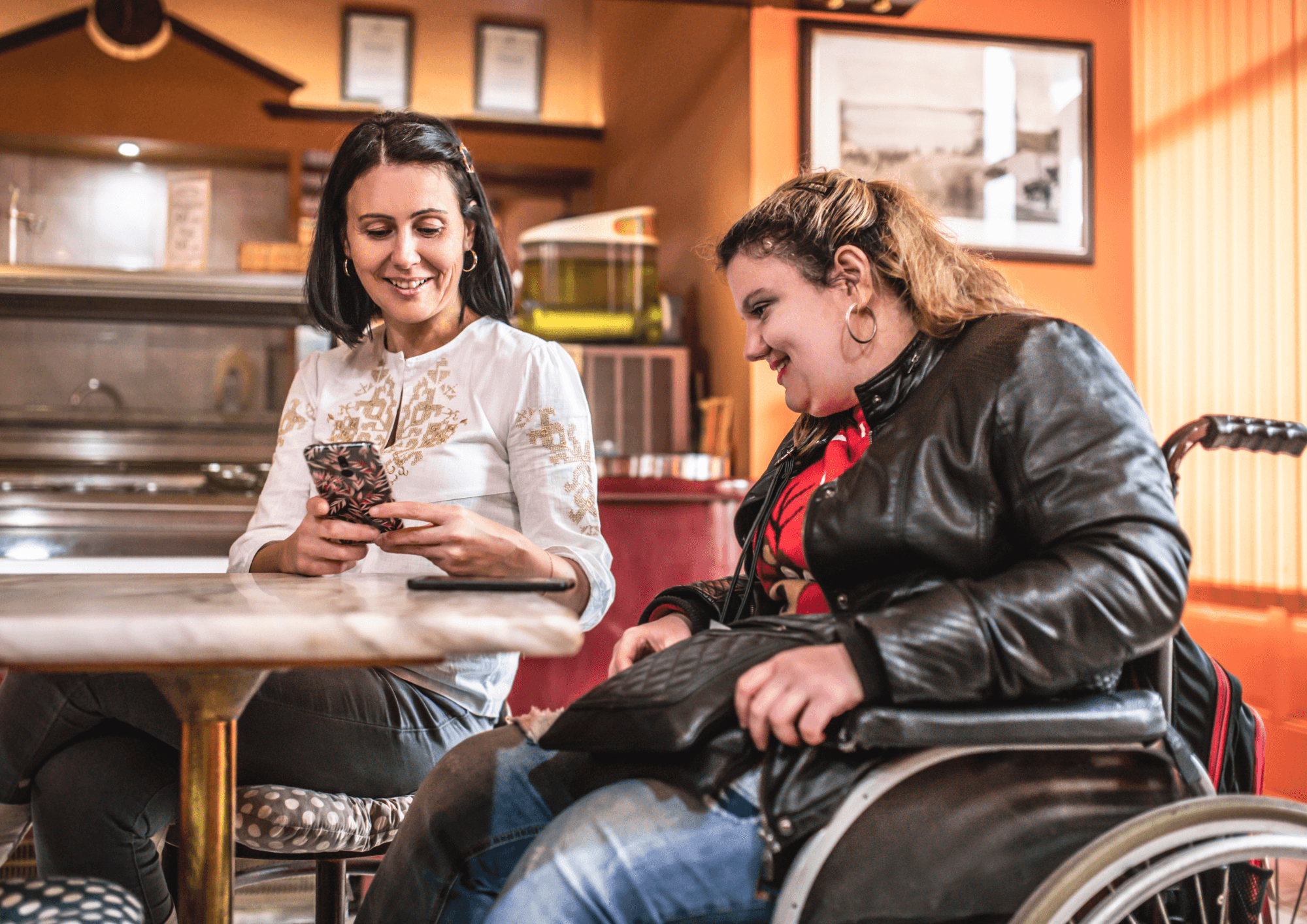 Two people at a table looking a a smart phone