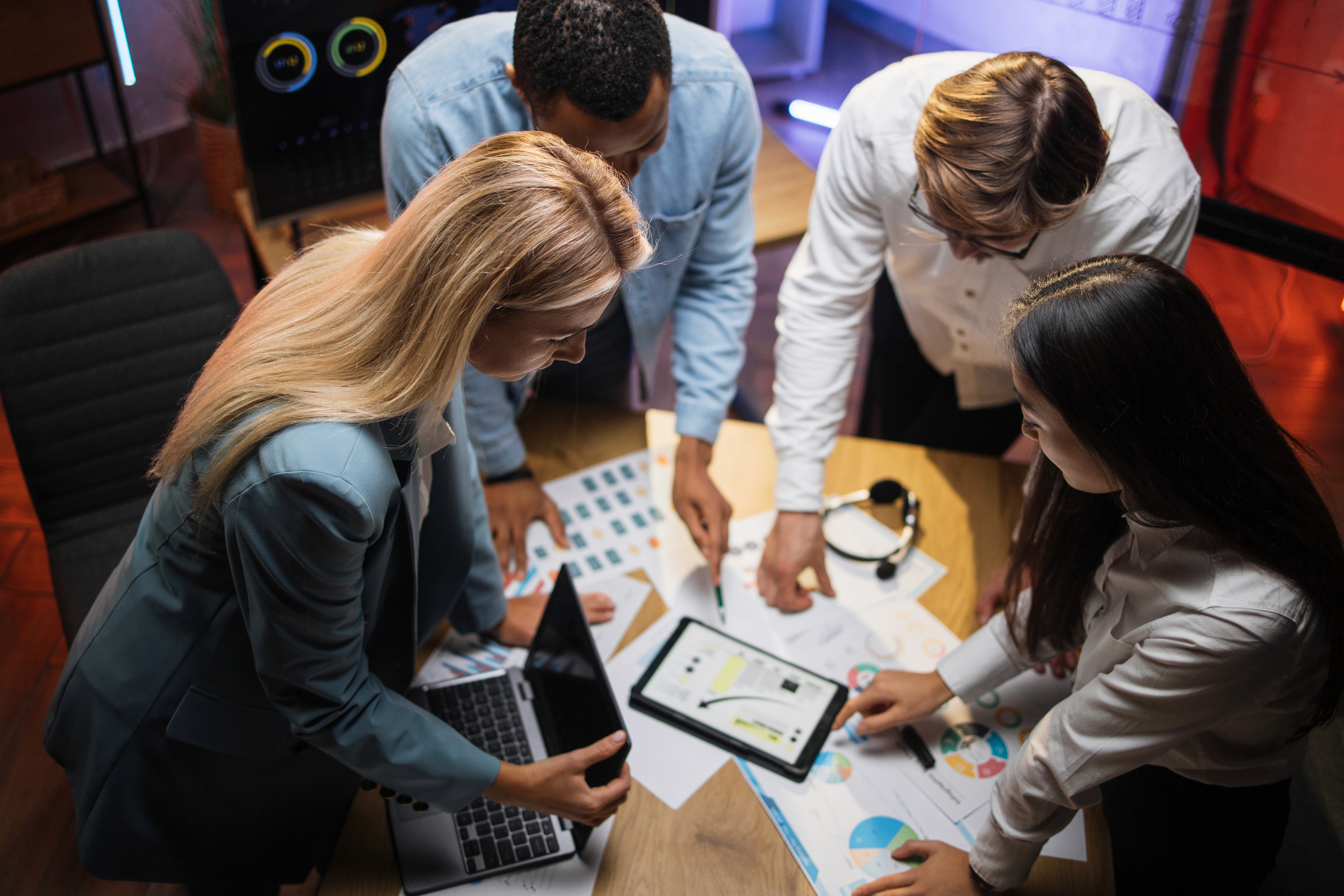Two stakeholders discussing data across devices, illustrating a business management consultant aligning marketing and finance for better decision-making.