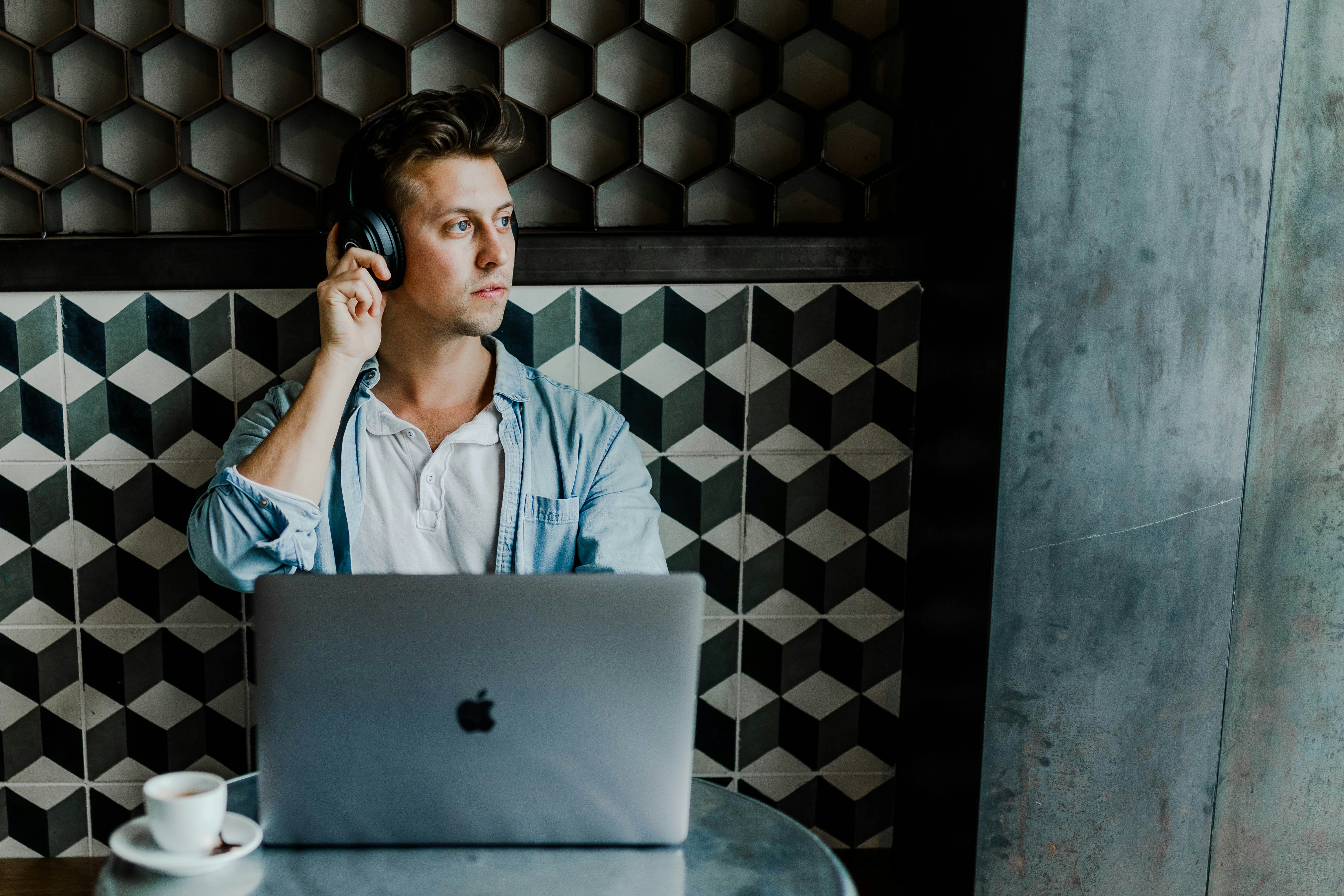 A man listening something in your headphones and using a notebook.