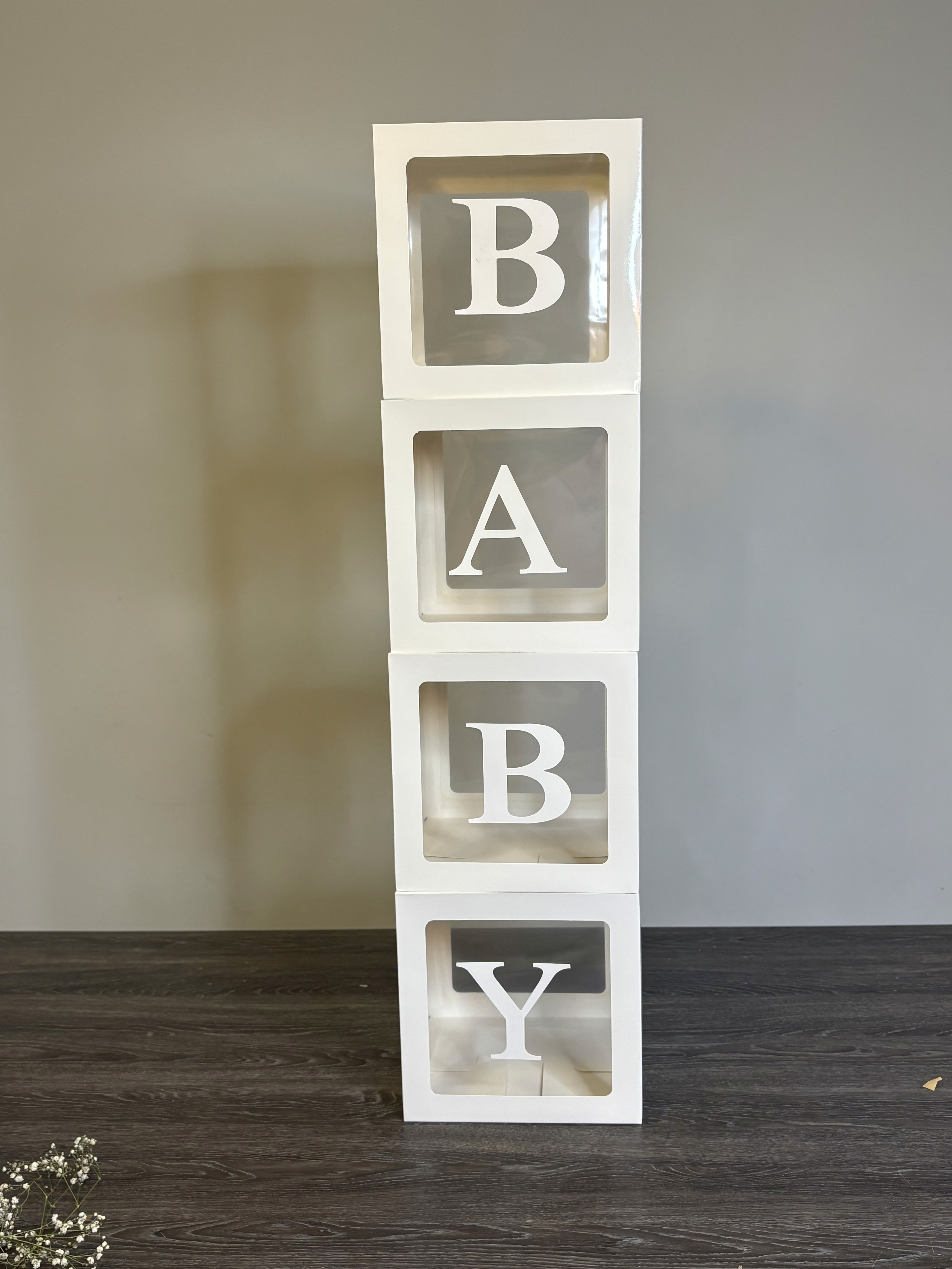 4 boxes with each box having a letter to spell Baby.