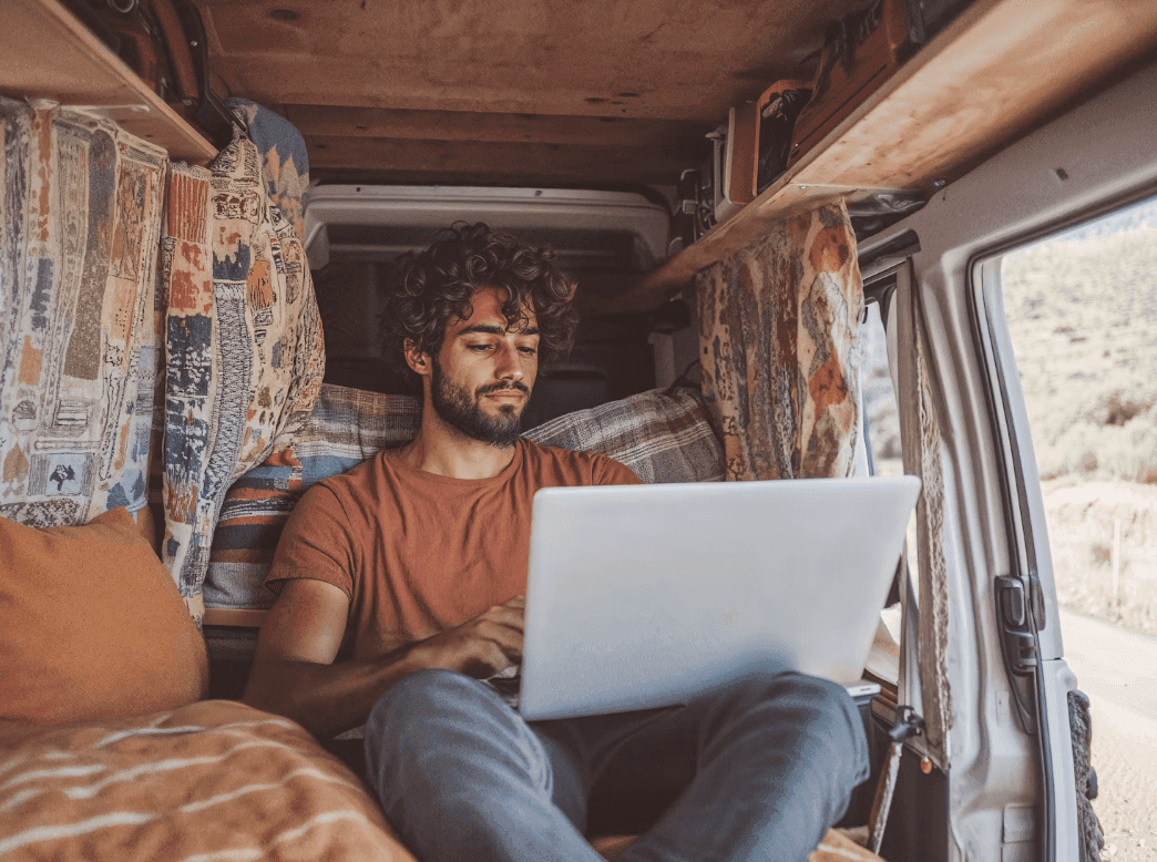 Person working on a laptop in a van.