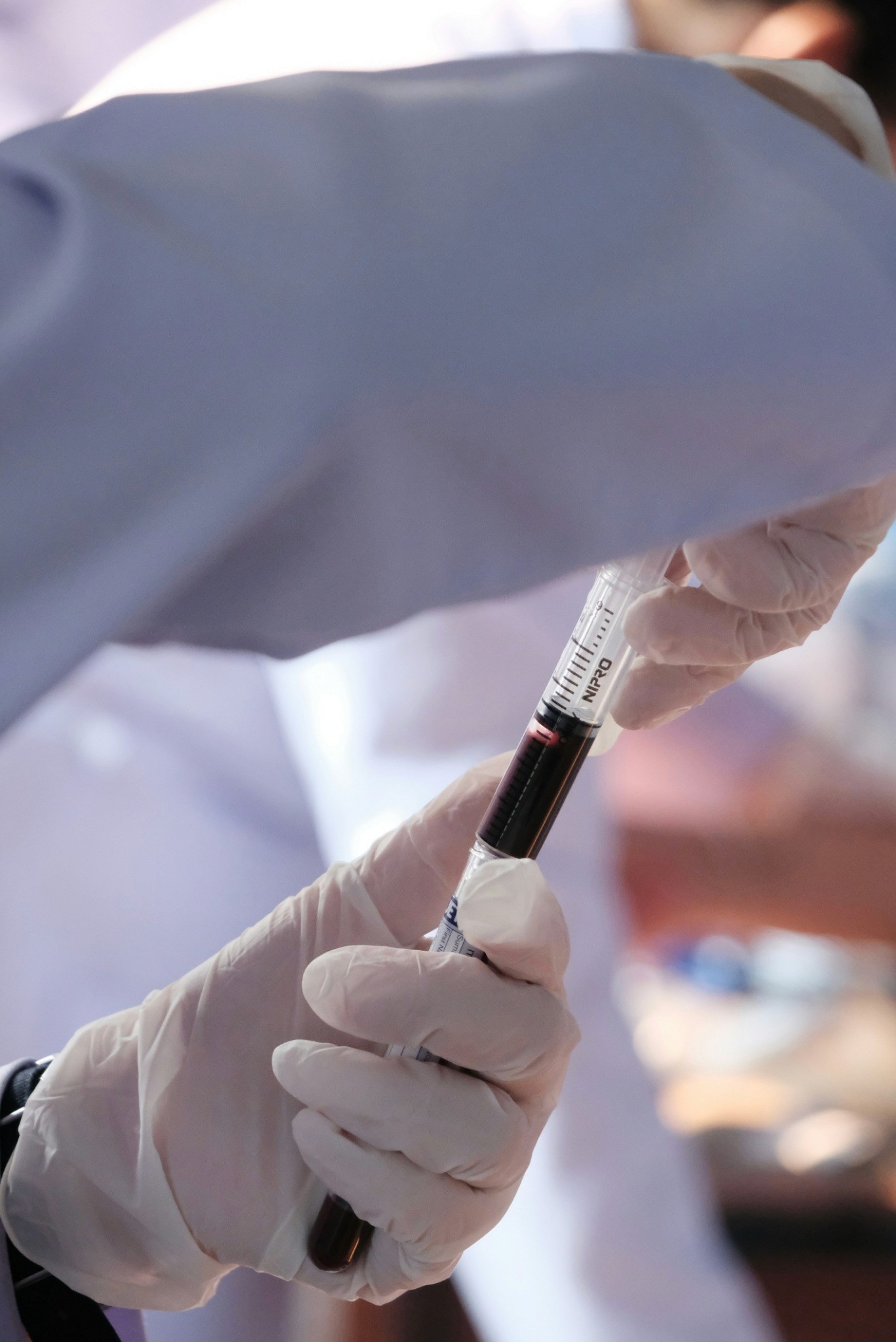 A person in white gloves is holding a syquet