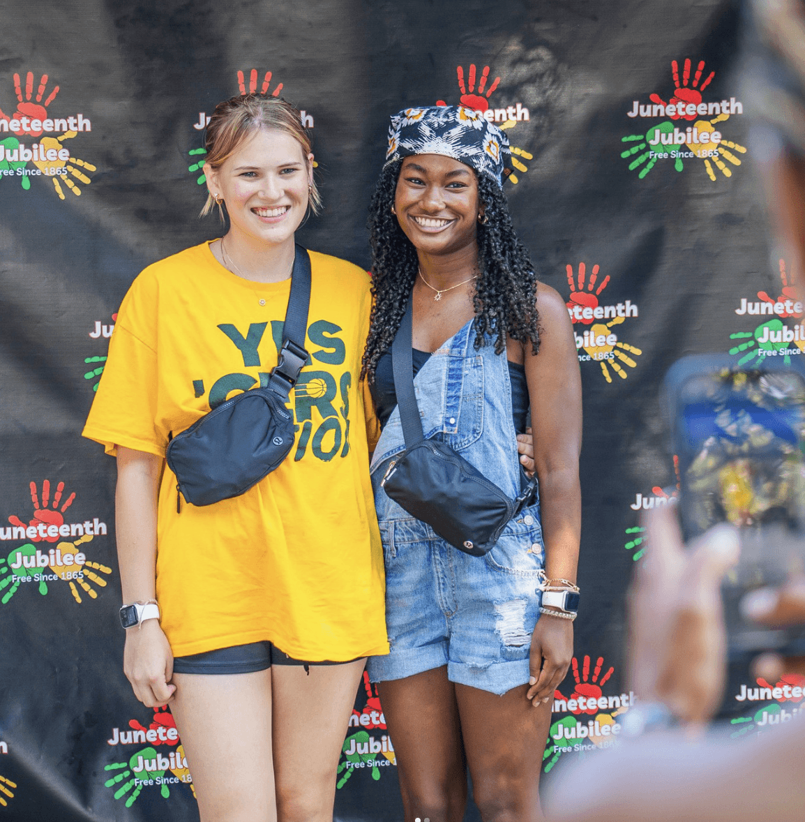 A lighthouse stands tall with an american flag.