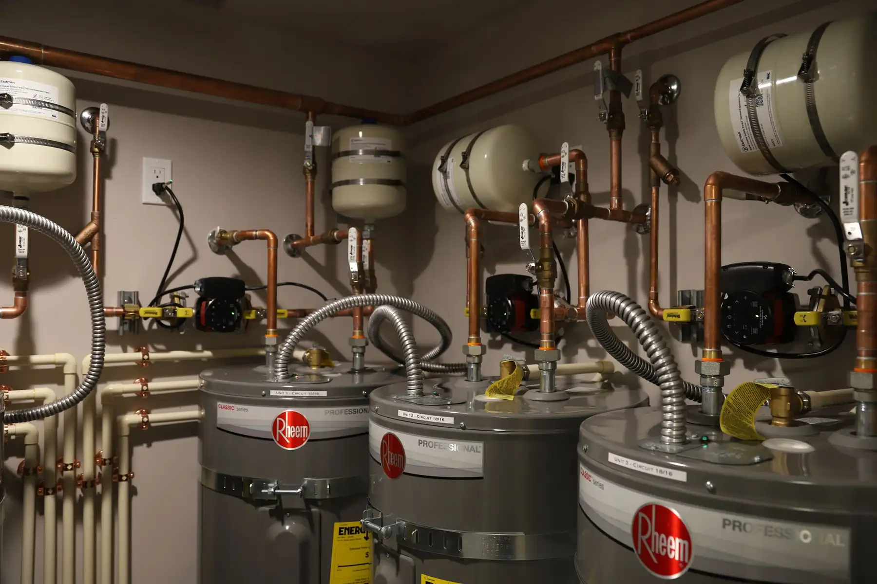 Three water heaters with circulator pumps and expansion tanks above them at Thrive Center in Hailey
