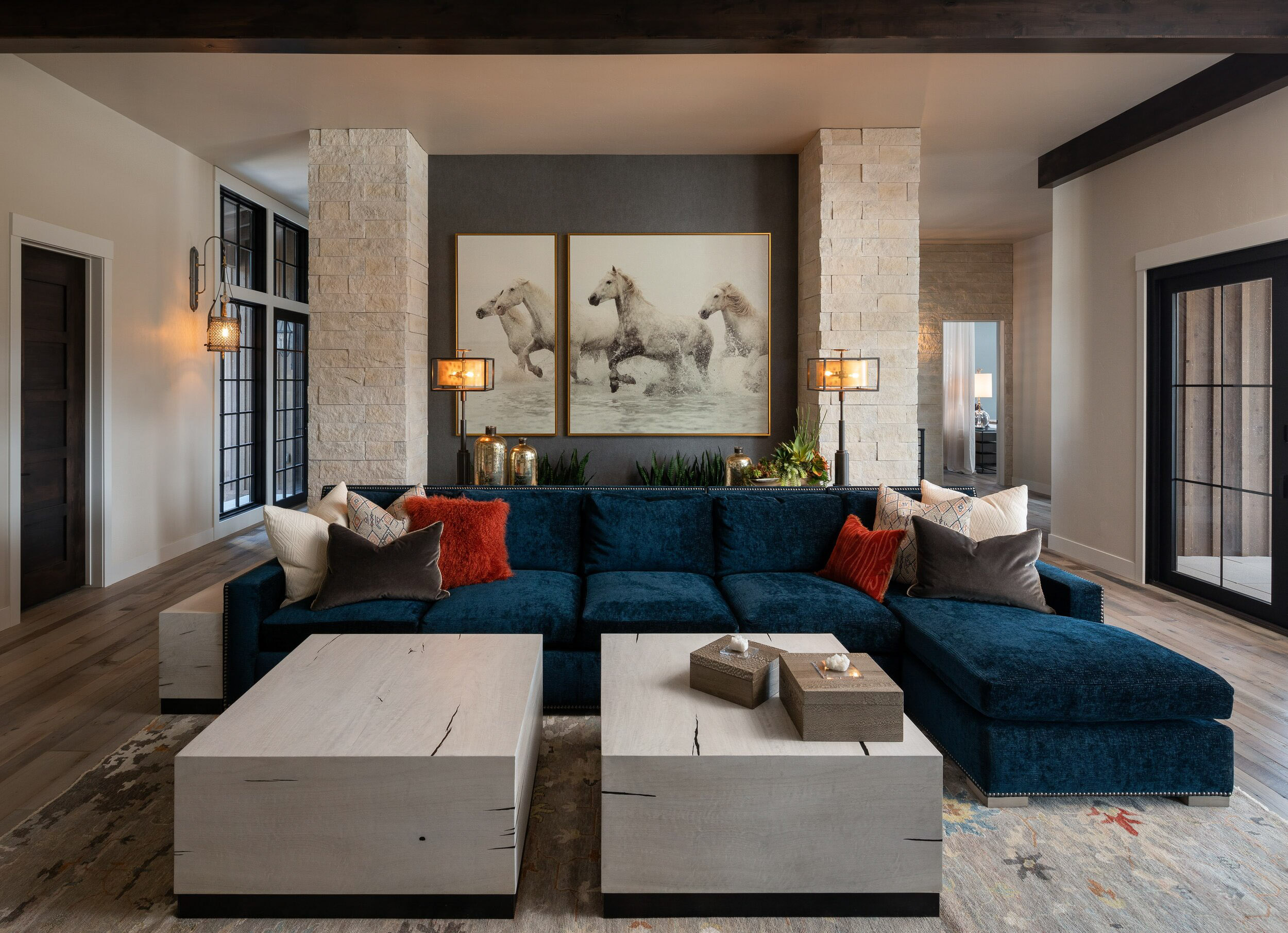 Dark blue sectional with horse art and two block coffee tables.