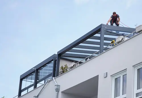 Harmes-Monteure montieren eine Terrassenüberdachung auf einer Dachterrasse