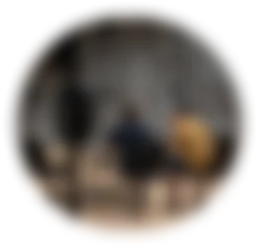 Deux personnes assises de dos devant un ordinateur dans un studio immersif équipé de multiples haut-parleurs suspendus et de panneaux acoustiques.