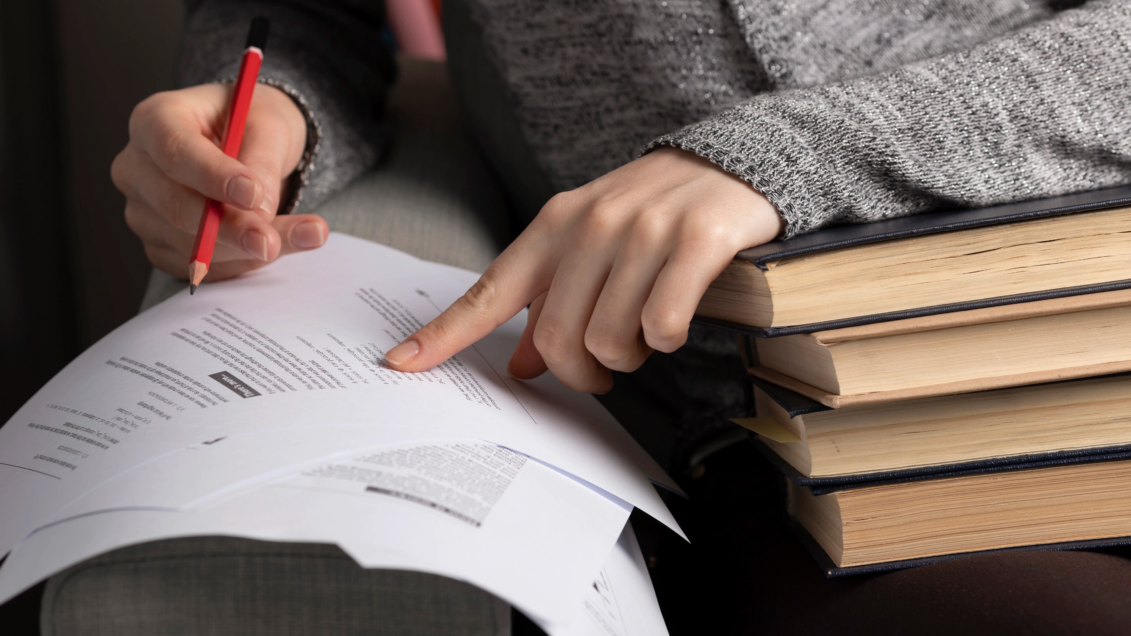 영화과 피칭 실기와 면접을 준비하는 학생이 빨간 연필을 들고 시놉시스 원고를 검토하고 있다. 옆에 쌓인 책들은 인문학적 소양과 영상분석 공부를 위한 참고 자료다.