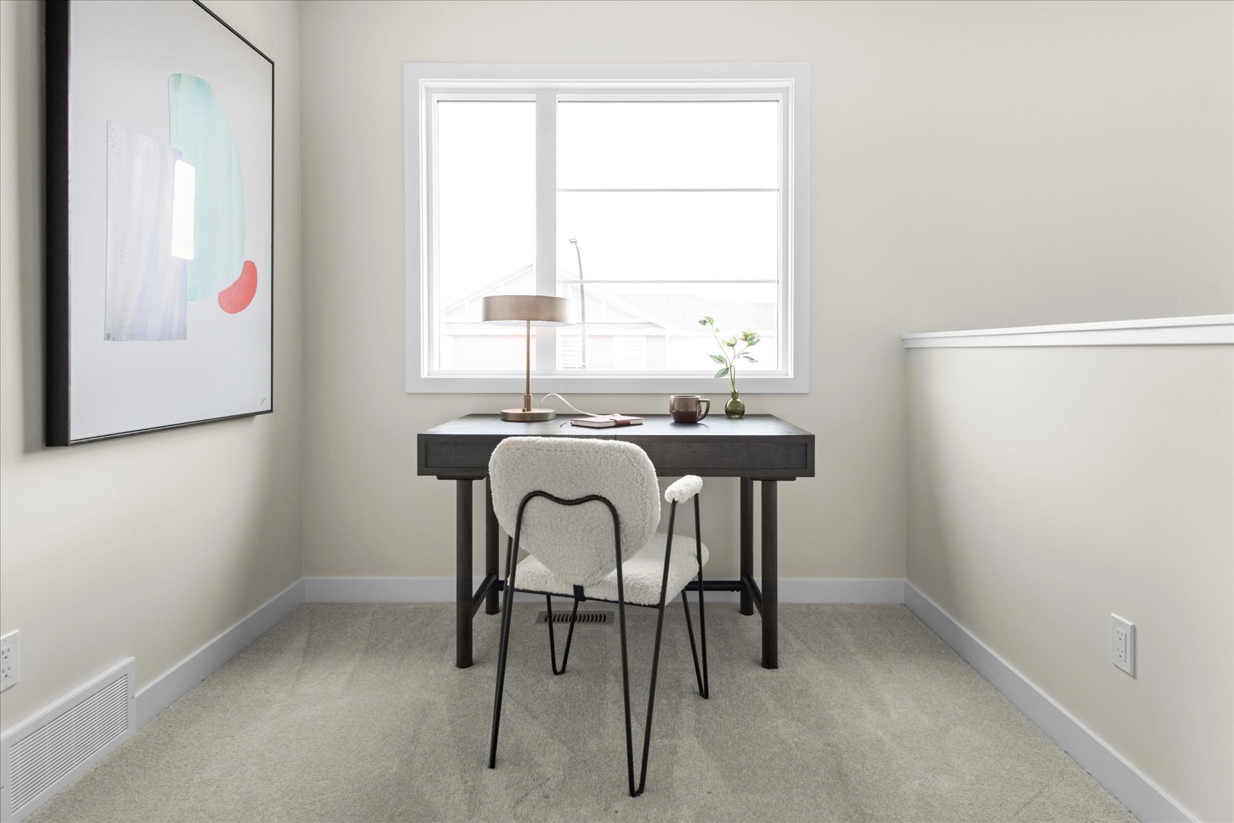 Heartland loft styled as an office with a desk, chair and framed artwork