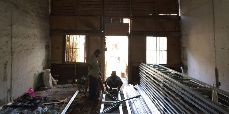 Two construction workers fixing an abandoned building in Chinatown, Kuala Lumpur