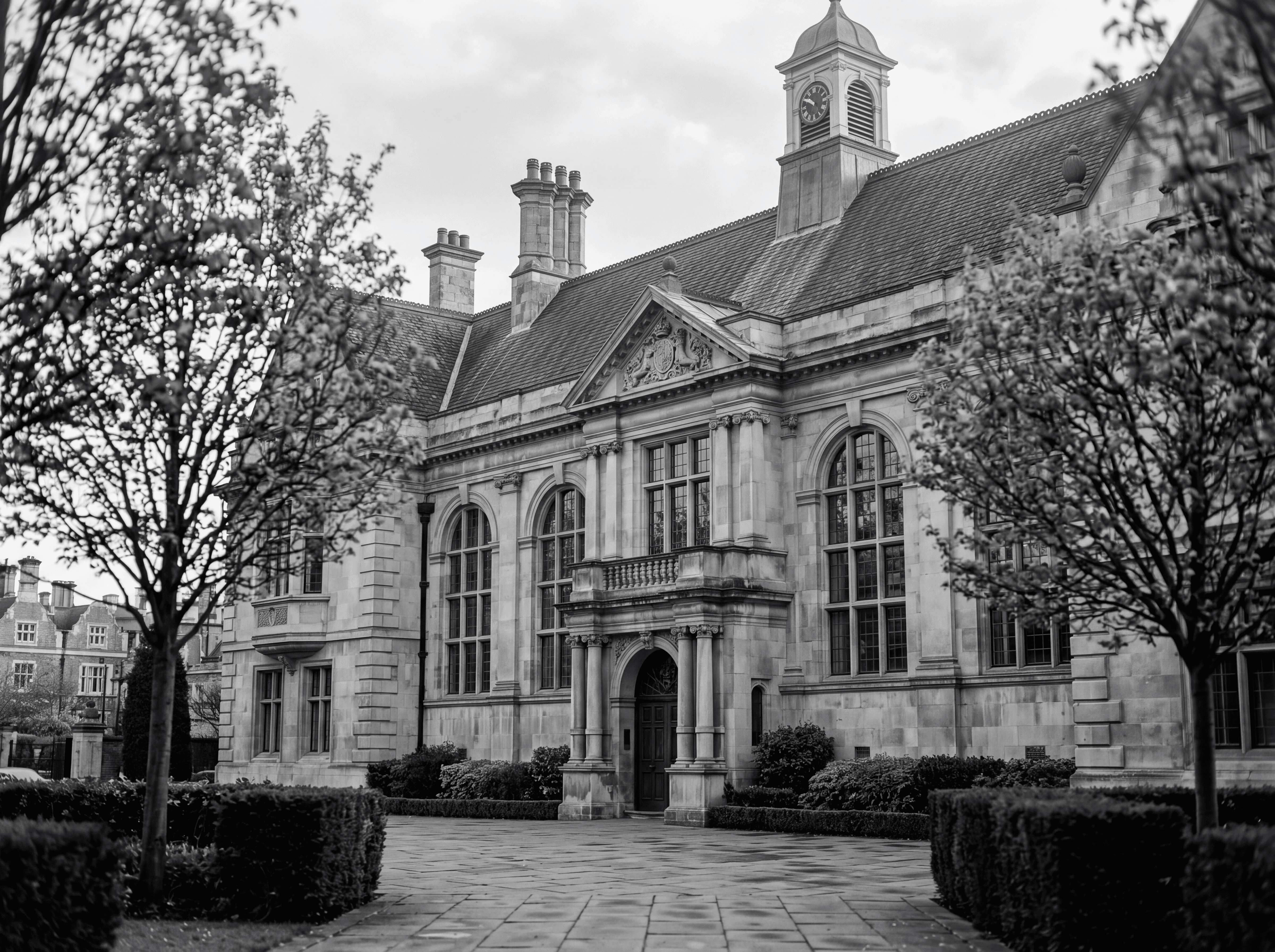 Classical exterior of a prestigious London independent school in early morning light, illustrating private school placement for Russian-speaking families, monochrome editorial photograph