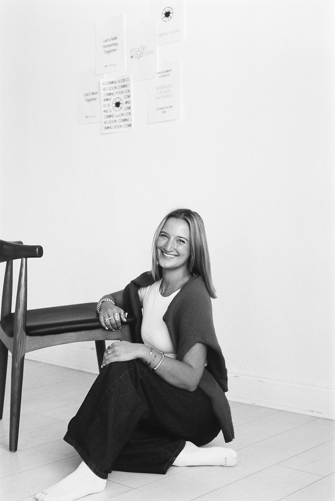 A close-up of a hand wearing multiple decorative rings against a blue background.