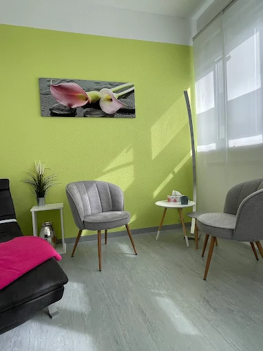 Eine Sitzecke, mit grüner Wand, Fenster und zwei Stühlen