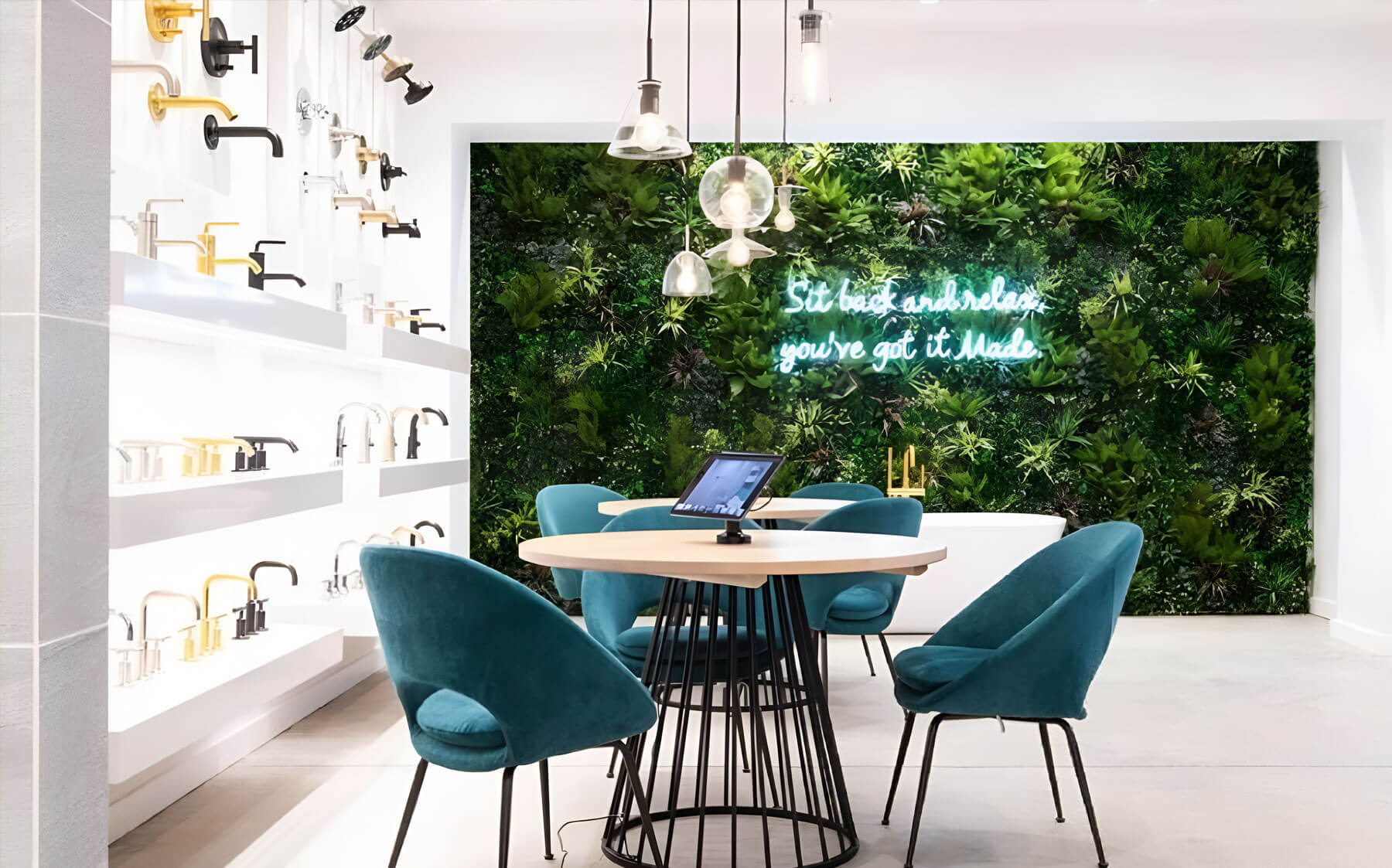 A modern faucet store featuring a VistaFolia green wall and stylish chairs for a fresh, inviting atmosphere.