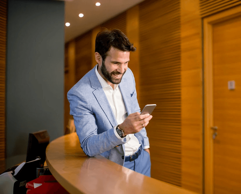 Man smiling checking his smartphone and the HoustonPlus app.