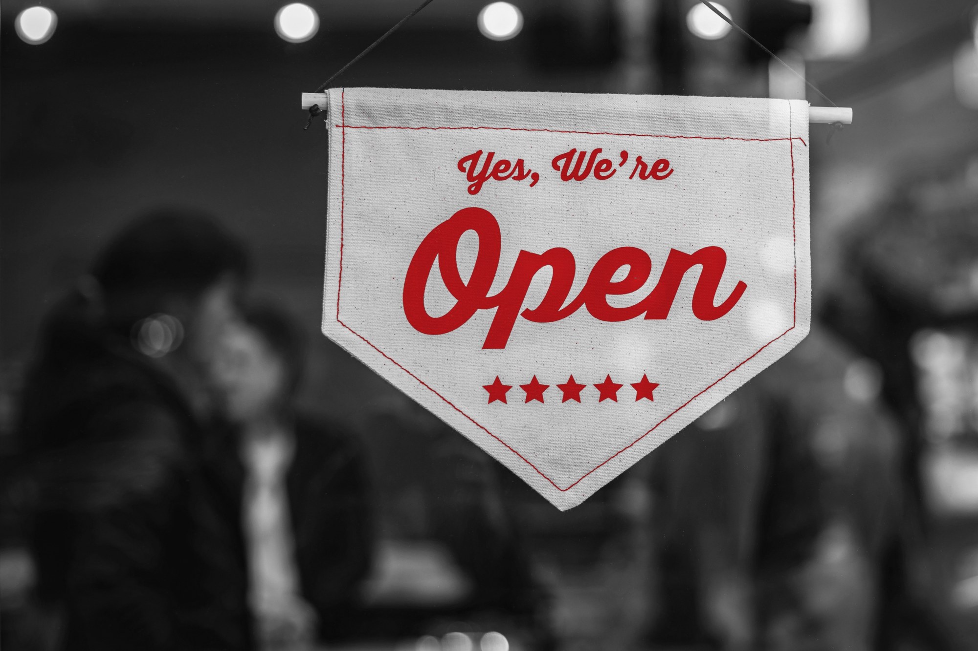 Open sign hanging in the window of a local small business
