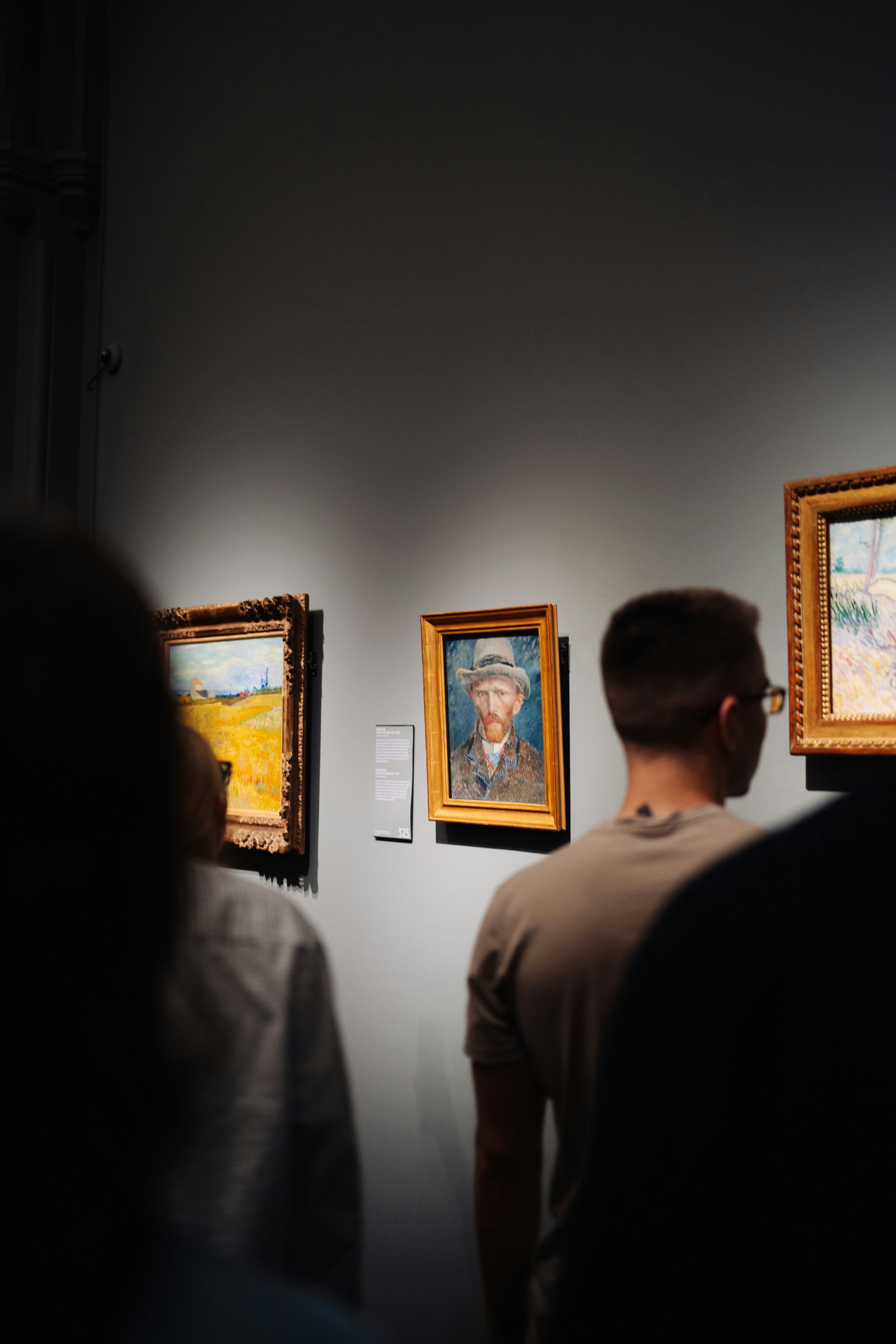 People viewing paintings in a museum gallery.