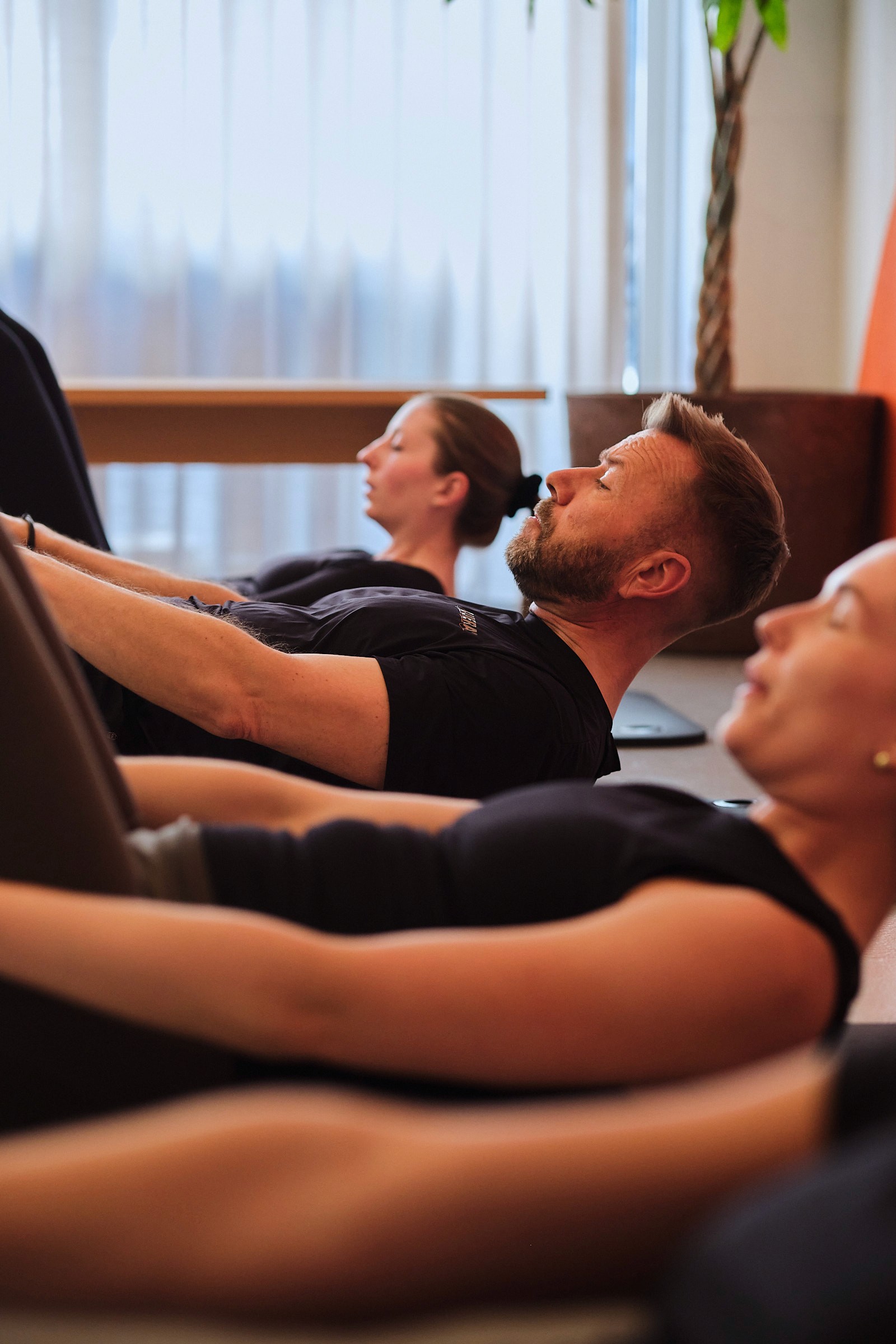 Kvinde bliver instrueret i pilates på cadillac maskinen