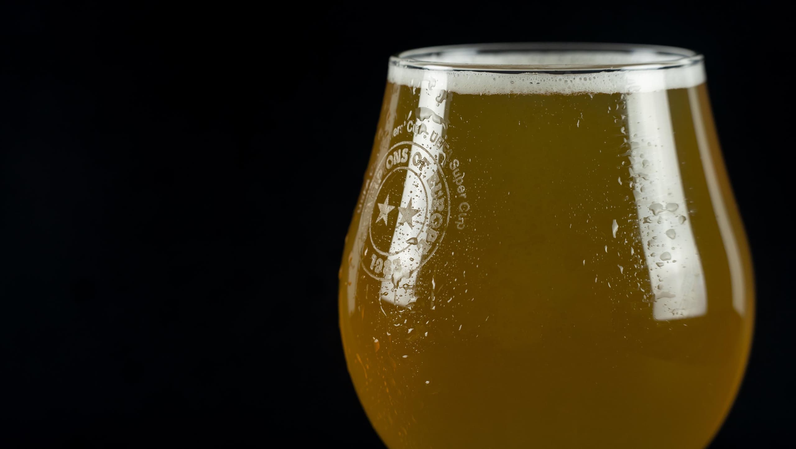 Glass of beer close-up on a black background