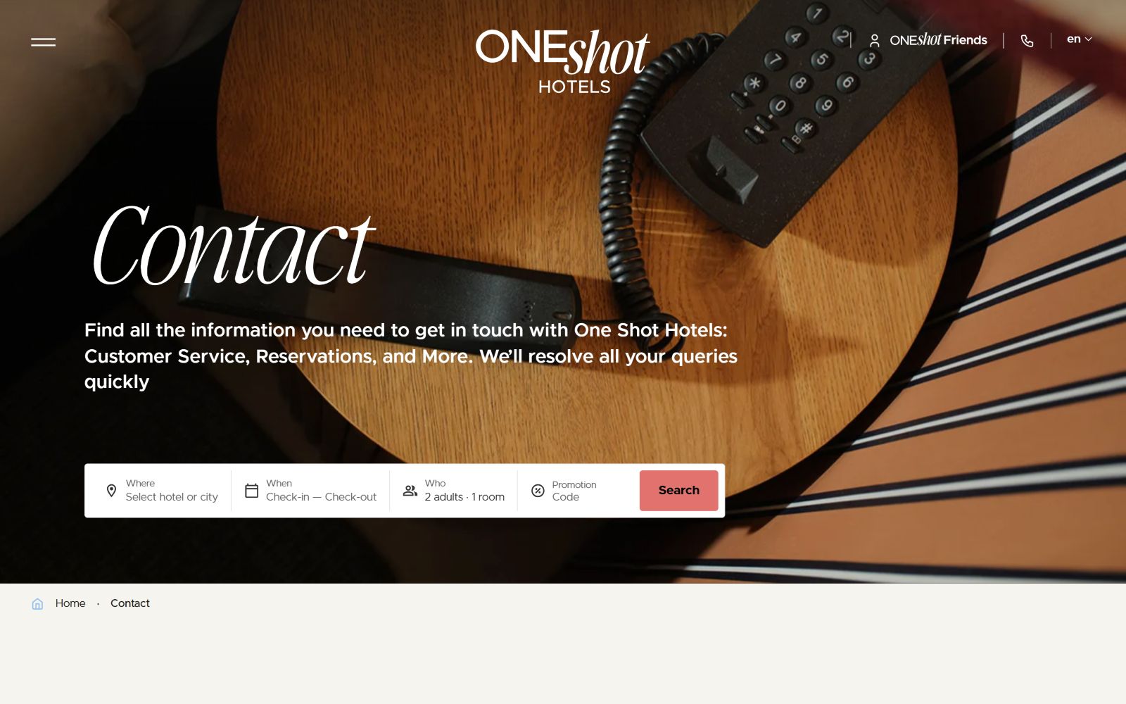 Round wooden table with a black phone, text: "Contact - OneShot Hotels." Search bar below with booking options.