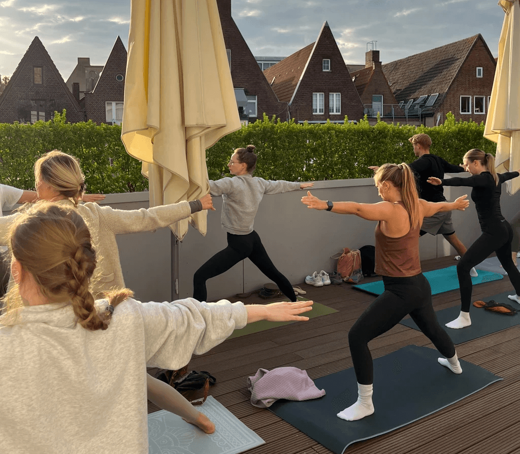 Junge Menschen beim Yoga machen auf einer Terrasse