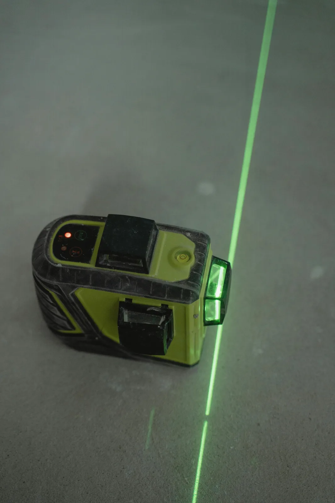 Laser level projecting green line on concrete floor