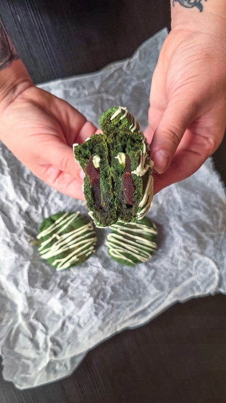 Fresh matcha cookie split open showing its chewy interior.