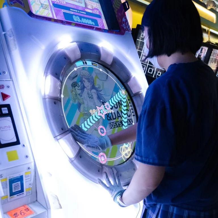 Person playing the Mai Mai arcade game